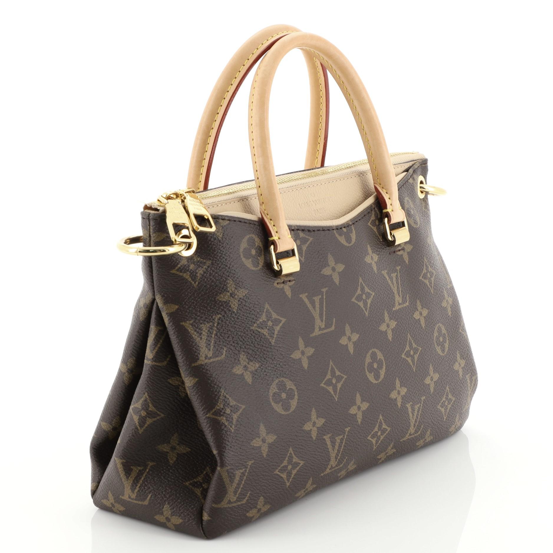 This Louis Vuitton Pallas Tote Monogram Canvas BB, crafted in brown monogram coated canvas, features dual-rolled handles, detachable strap and gold-tone hardware. Its zip closure opens to a neutral microfiber interior with slip pockets. Authenticity
