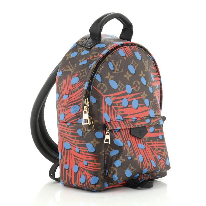 This Louis Vuitton Palm Springs Backpack Limited Edition Monogram Jungle Dots PM, crafted from brown monogram coated canvas, features adjustable shoulder straps, leather top handle, pink and red jungle dots, front zip pocket, and gold-tone hardware.
