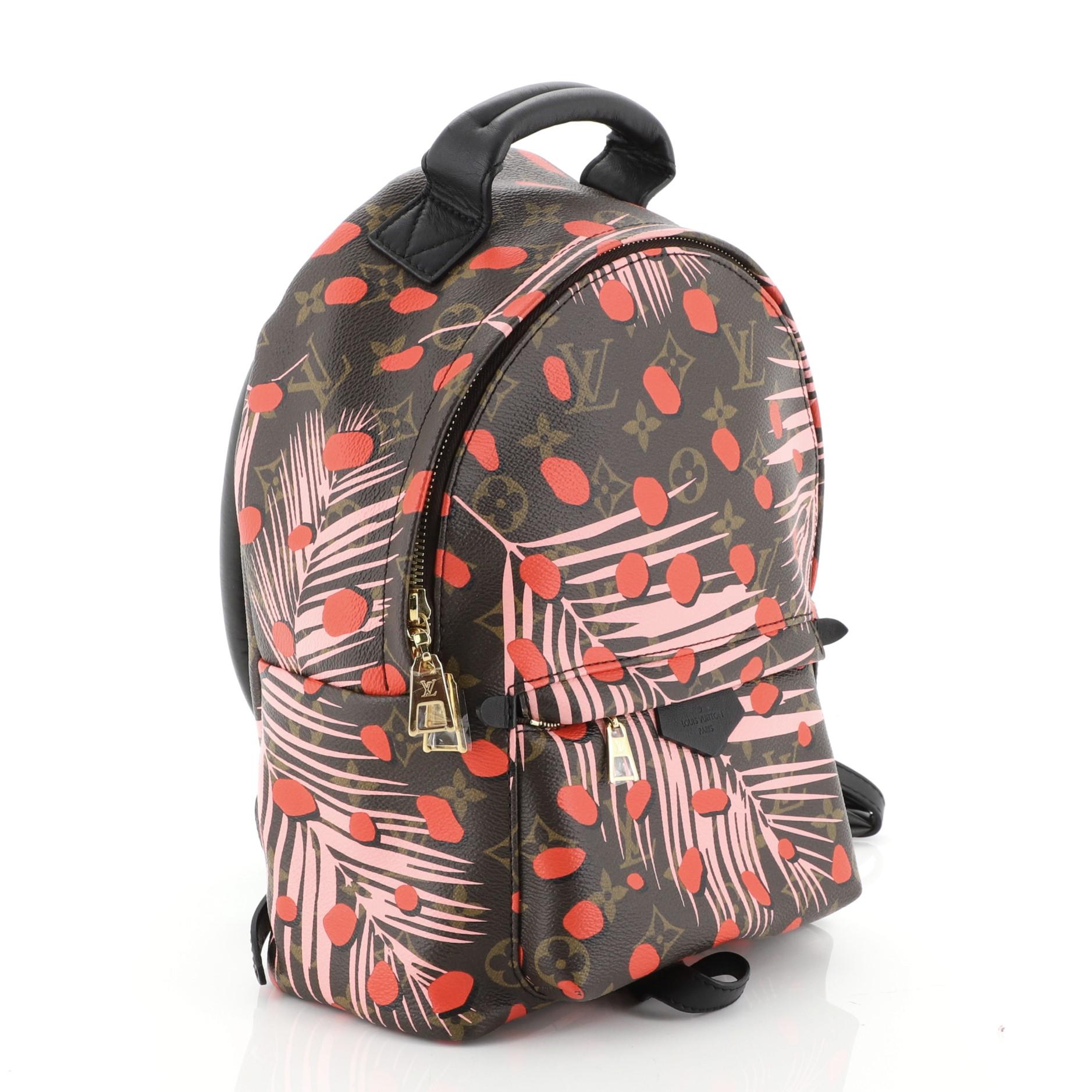 This Louis Vuitton Palm Springs Backpack Limited Edition Monogram Jungle Dots PM, crafted from brown monogram pink and red jungle dots coated canvas, features adjustable shoulder straps, leather top handle, front zip pocket, and gold-tone hardware.