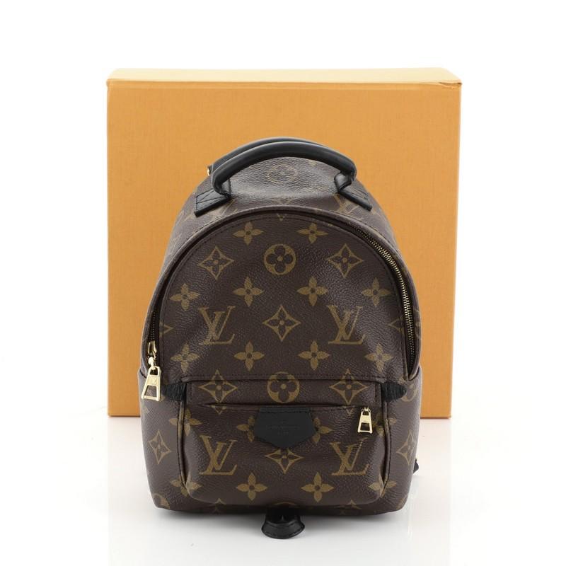 This Louis Vuitton Palm Springs Backpack Monogram Canvas Mini, crafted from brown monogram coated canvas, features a padded leather top handle, adjustable backpack shoulder straps, exterior front zip pocket, foam backing, and gold-tone hardware. Its