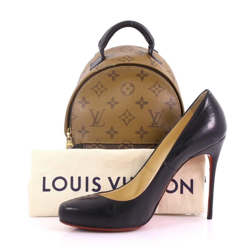 This Louis Vuitton Palm Springs Backpack Reverse Monogram Canvas Mini, crafted from brown reverse monogram coated canvas, features a padded leather top handle, adjustable shoulder straps, an exterior front zip pocket, and gold-tone hardware. Its zip