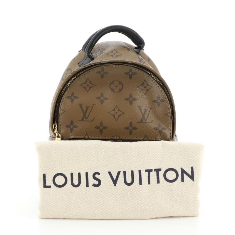 This Louis Vuitton Palm Springs Backpack Reverse Monogram Canvas Mini, crafted from brown reverse monogram coated canvas, features a padded leather top handle, adjustable shoulder straps, an exterior front zip pocket, and gold-tone hardware. Its zip