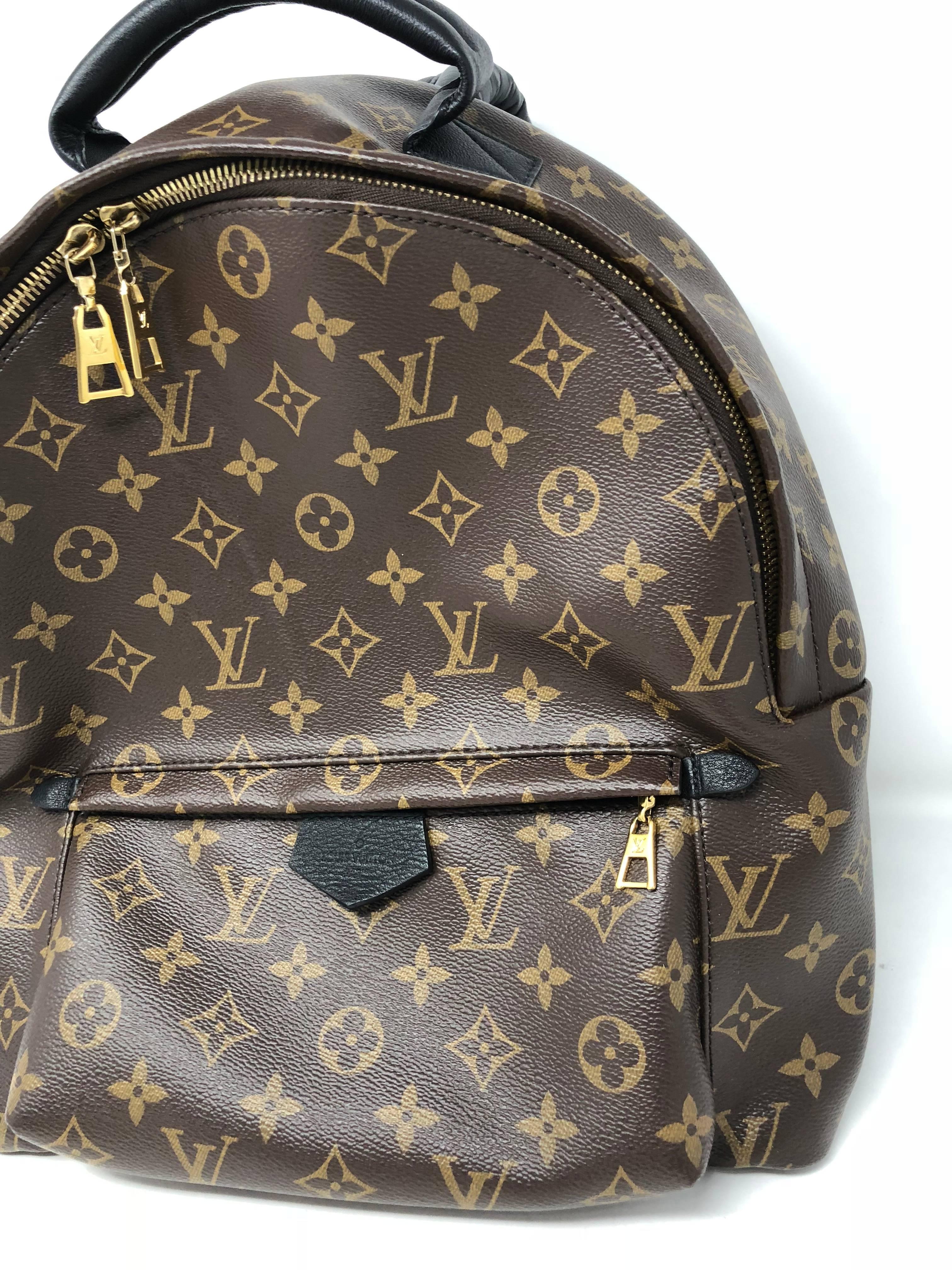 Louis Vuitton Backpack Palm Springs MM in monogram.  This backpack has signature monogram with black calfskin trim for a defined look and matching black top handle and straps. The thick straps are adjustable and comfortable. Backpack is in mint