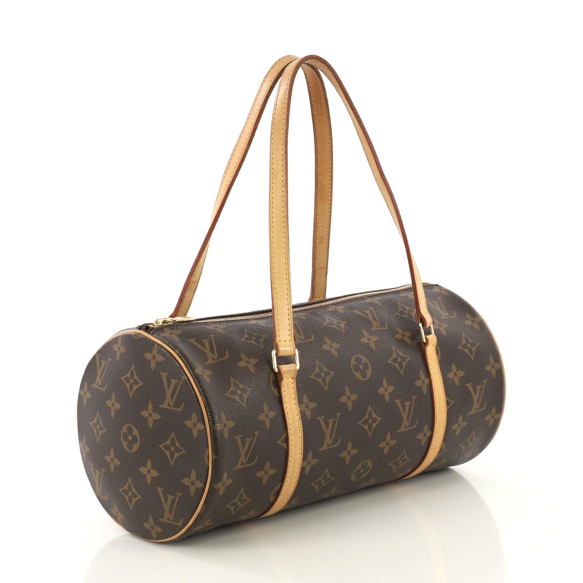 This Louis Vuitton Papillon Handbag Monogram Canvas 30, crafted with brown monogram coated canvas, features dual leather handles, leather trim, and gold-tone hardware. Its zip closure opens to a brown leather interior. Authenticity code reads: