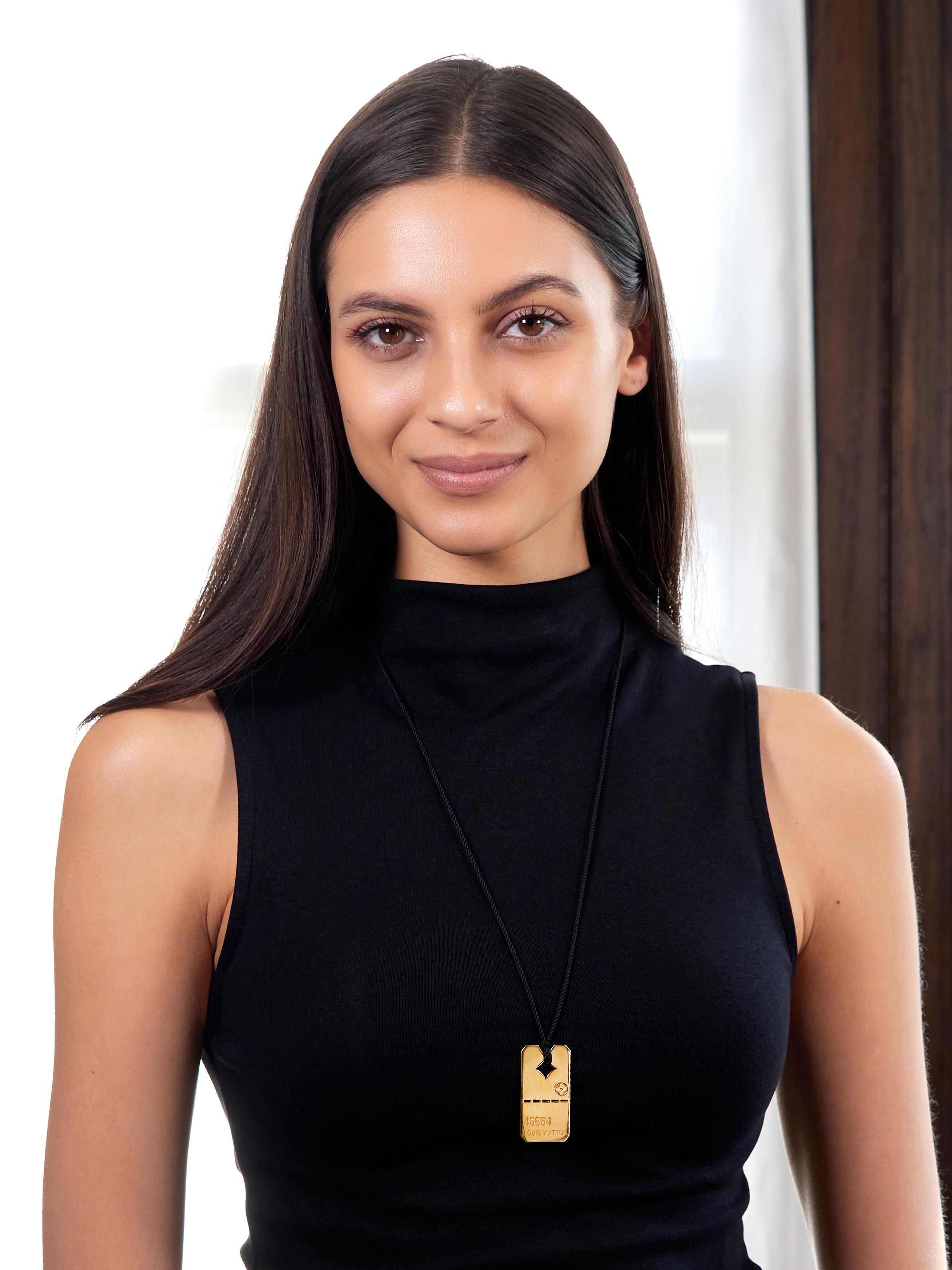 Designed as a yellow gold dog tag suspending from a black twisted rope silk cord
Tag is pierced with logo style diamond and dashed line motif
Engraved with logo flower, number, and brand name
Inscribed with edition number '001/466' on back
Cord