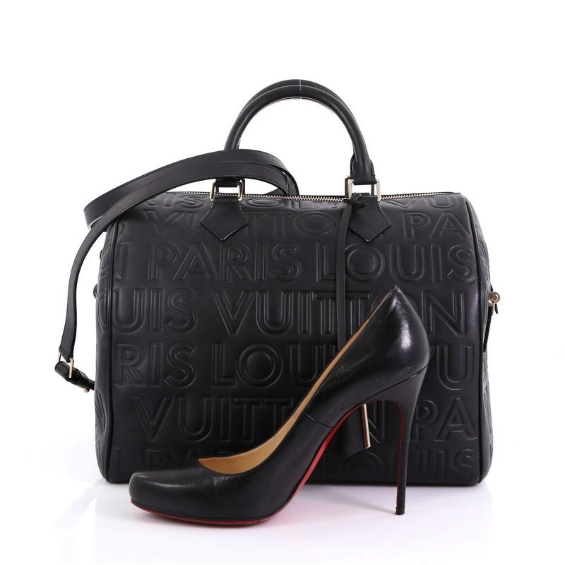 This Louis Vuitton Paris Speedy Cube Bag Embossed Leather 30, crafted from black leather, features embossed Paris Louis Vuitton lettering, dual rolled handles with metal accents, protective base feet, and gold-tone hardware. Its zip closure opens to