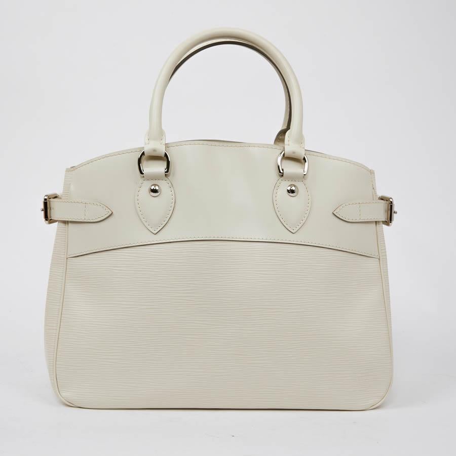 Second-hand Louis Vuitton bag in ivory epi leather. It is carried by hand with its double handle. The trim is in silver metal. The interior is in beige canvas. It has two storage compartments separated by a large zipped pocket. It is in very good