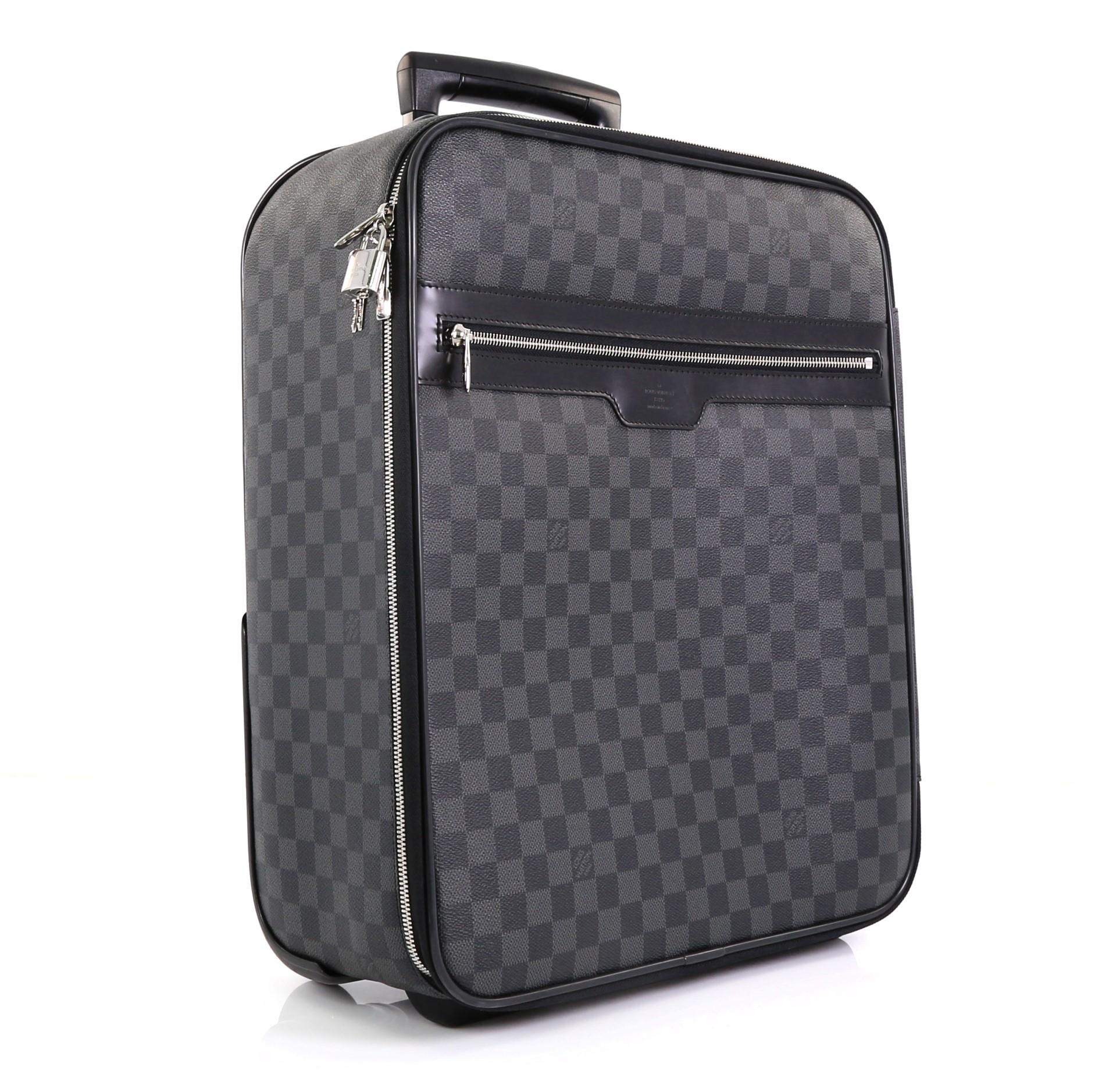 This Louis Vuitton Pegase Luggage Damier Graphite 45, crafted in damier graphite coated canvas, features exterior zip pocket, retractable handle with lock button, silent rolling system and silver-tone hardware. Its zip closure opens to a black
