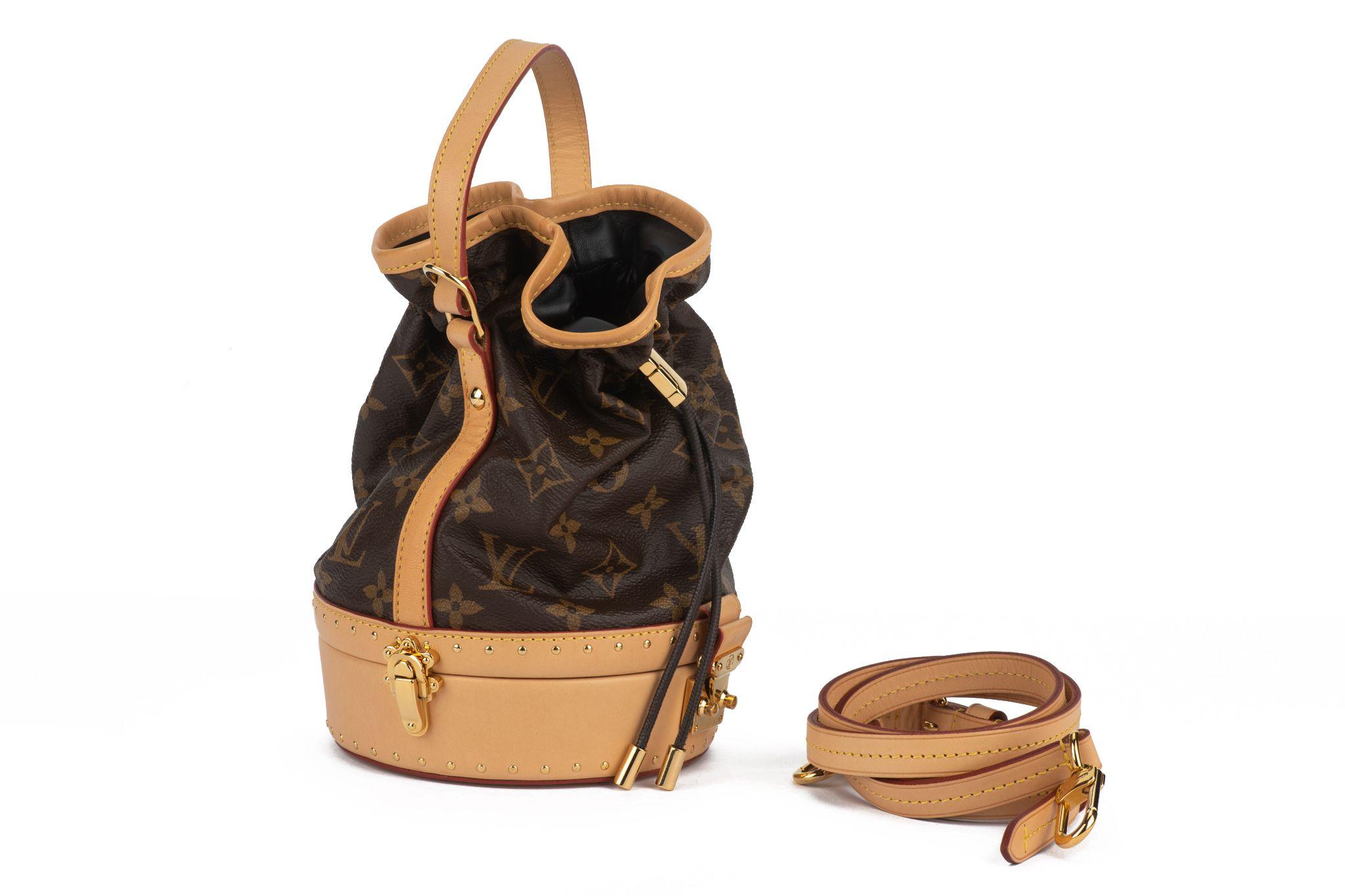The Louis Vuitton Monogram Petit Noe Trunk handbag is crafted of monogram coated canvas with a calfskin leather trim. Features brass hardware, single flat top handle drop 4.5