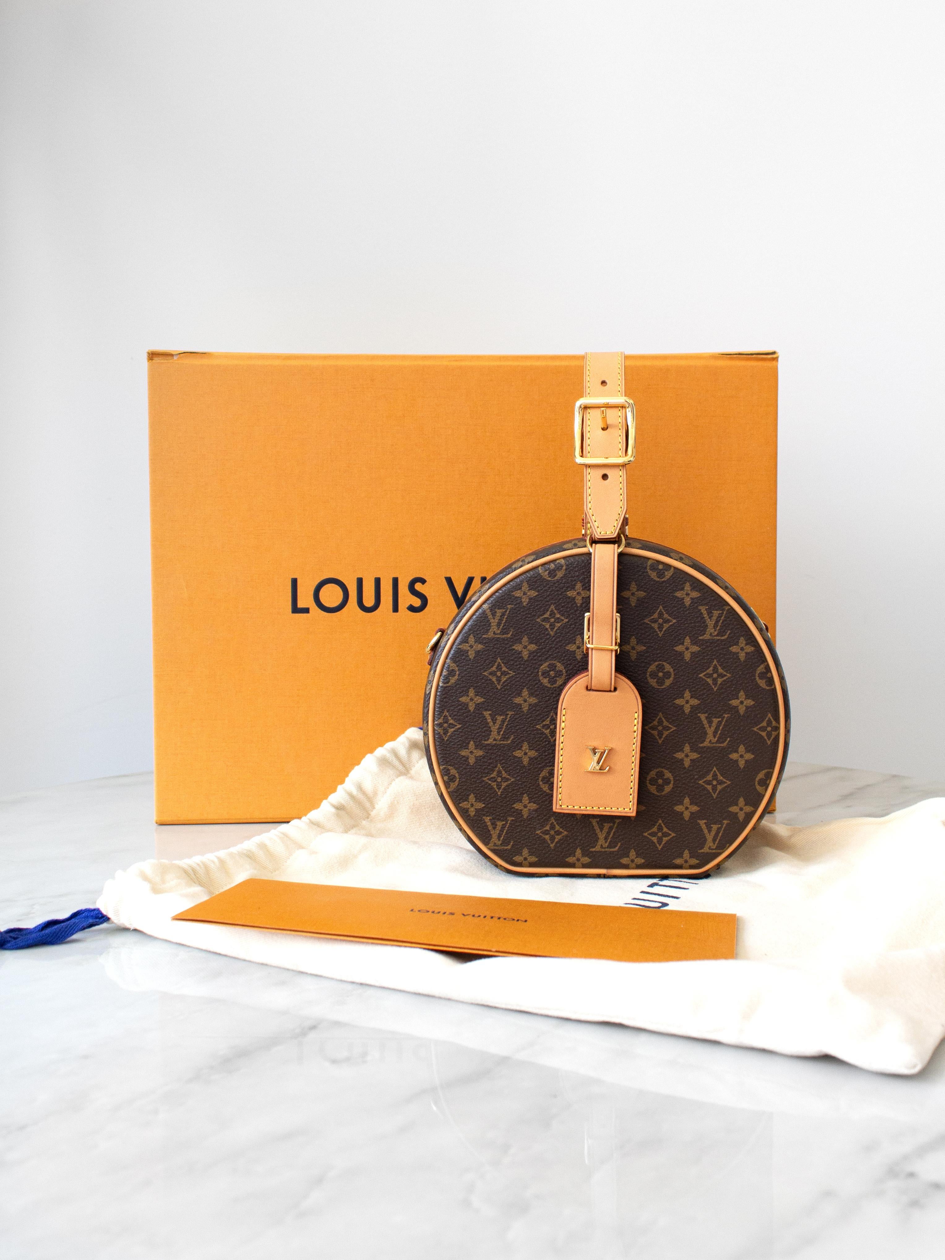 Introducing the Louis Vuitton Petite Boîte Chapeau: a charming bag inspired by the classic hatbox. This rare first edition bag, dating back to 2018, boasts a petite yet practical design crafted from classic coated monogram canvas adorned with