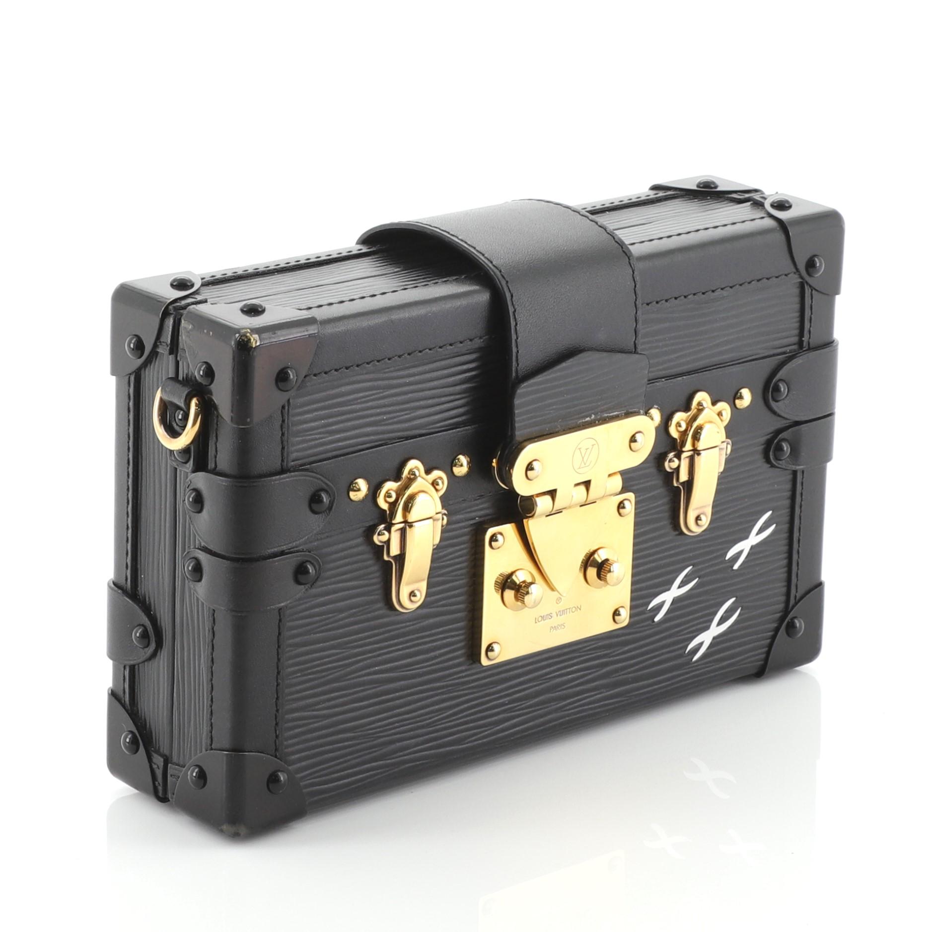 This Louis Vuitton Petite Malle Handbag Epi Leather, crafted in black epi leather, features a detachable leather strap, black leather trim, LV's three white signature crosses and gold-tone hardware. Its S-lock closure opens to a neutral leather