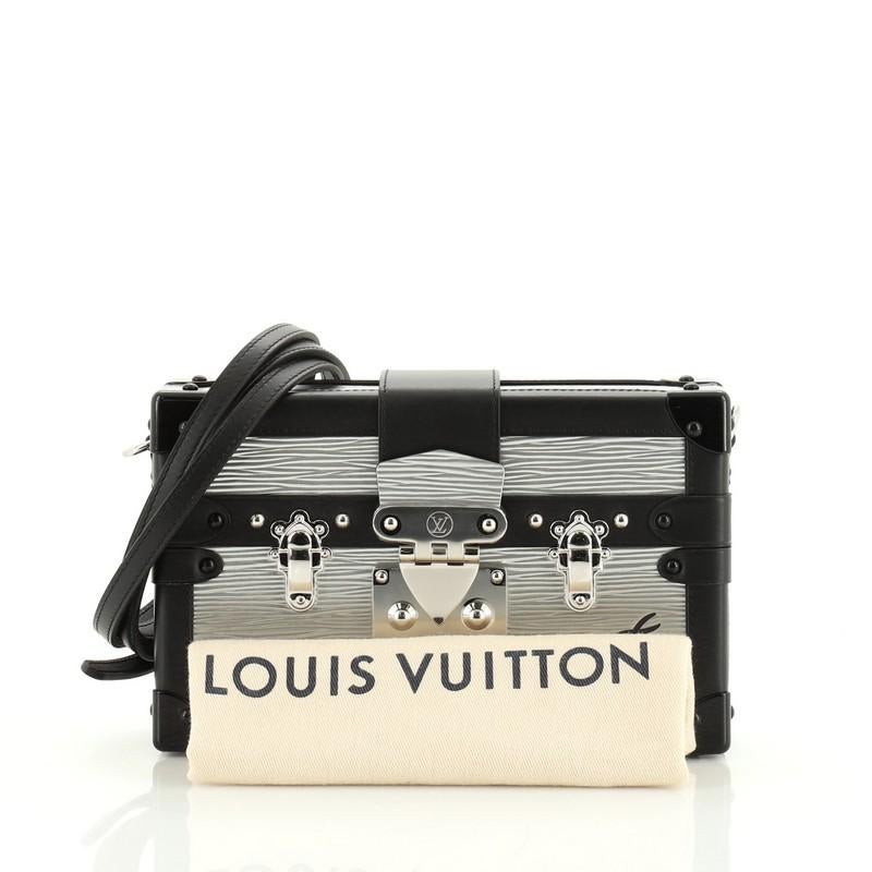This Louis Vuitton Petite Malle Handbag Epi Leather, crafted in black and silver leather, features a detachable leather strap, leather trim, LV's three signature crosses and silver-tone hardware. Its S-lock closure opens to a neutral leather
