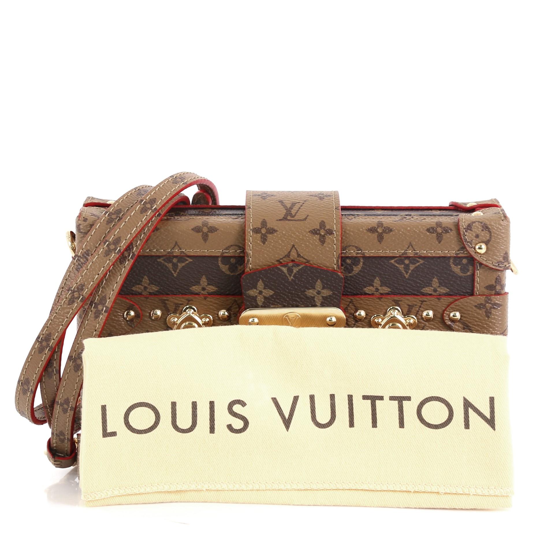 
This Louis Vuitton Petite Malle Handbag Reverse Monogram Canvas, crafted from brown reverse monogram coated canvas, features the signature three red crosses and gold-tone hardware. Its S-lock closure opens to a neutral leather interior with side