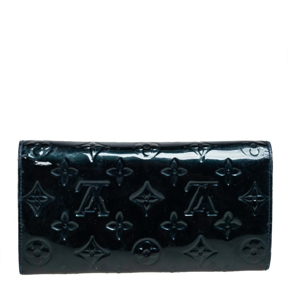 One of the most famous wallets by Louis Vuitton is the Sarah. This one here comes made from Monogram Vernis and the button on the flap opens to an interior with multiple card slots and a zip pocket. Perfect in size, this wallet can easily fit inside