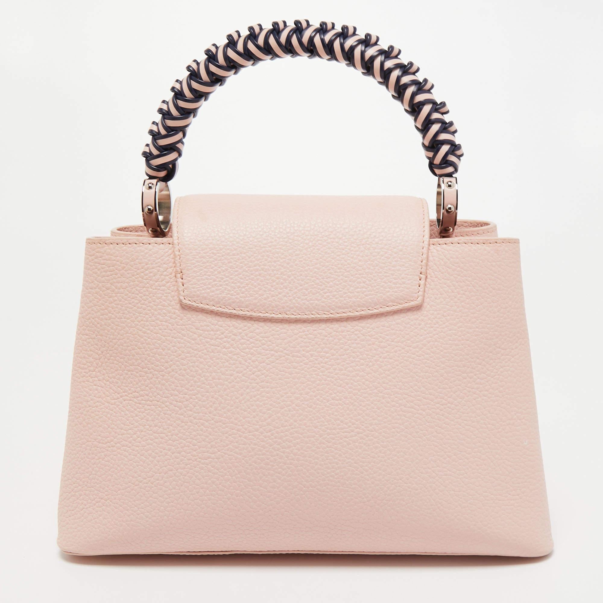 It is every woman's dream to own a Louis Vuitton handbag as appealing as this one. Crafted from leather, this bag features a structured design with a single handle and protective metal feet. While the front LV elevates its beauty, the leather
