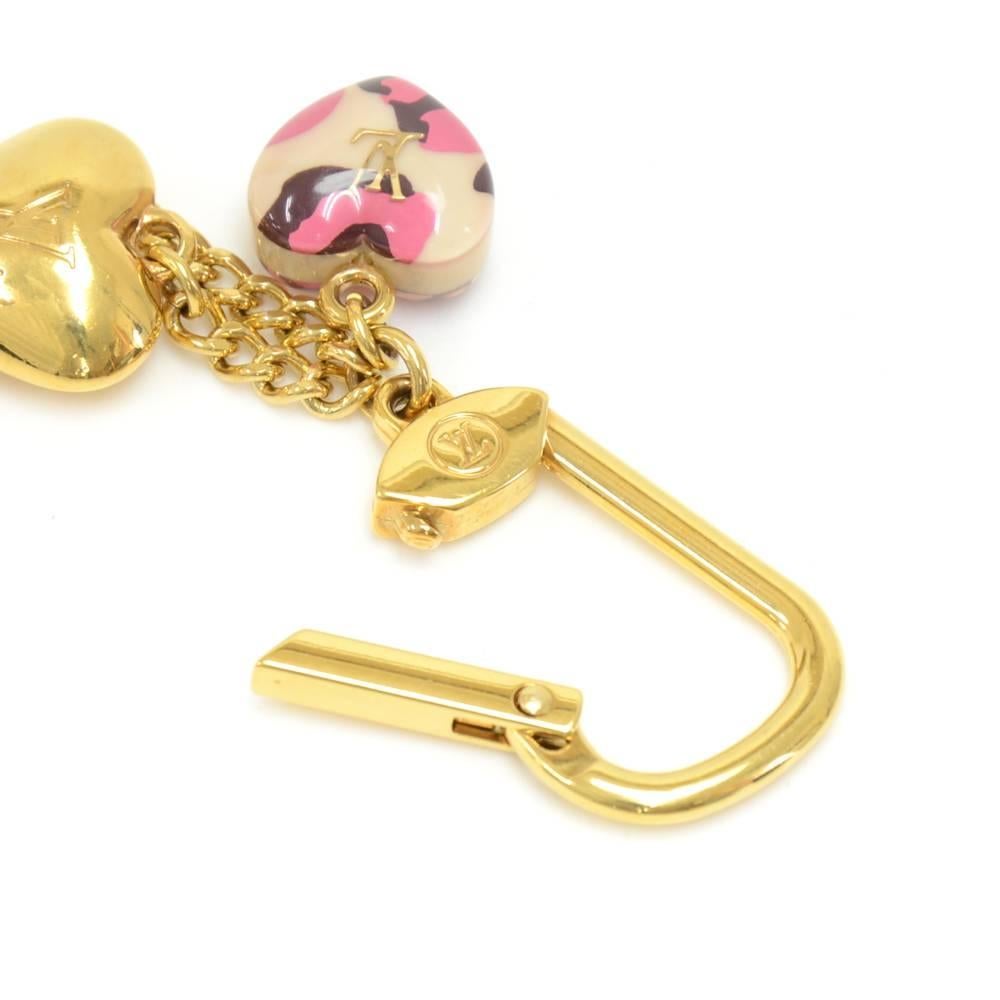 Louis Vuitton Key holder/Bag charm in pink leopard print.  Has 2 pink leopard print hearts with a gold LV logo in the center and one gold-tone heart charm with the LV logo engraved in the center. Very cute and chic. Great for keeping your keys