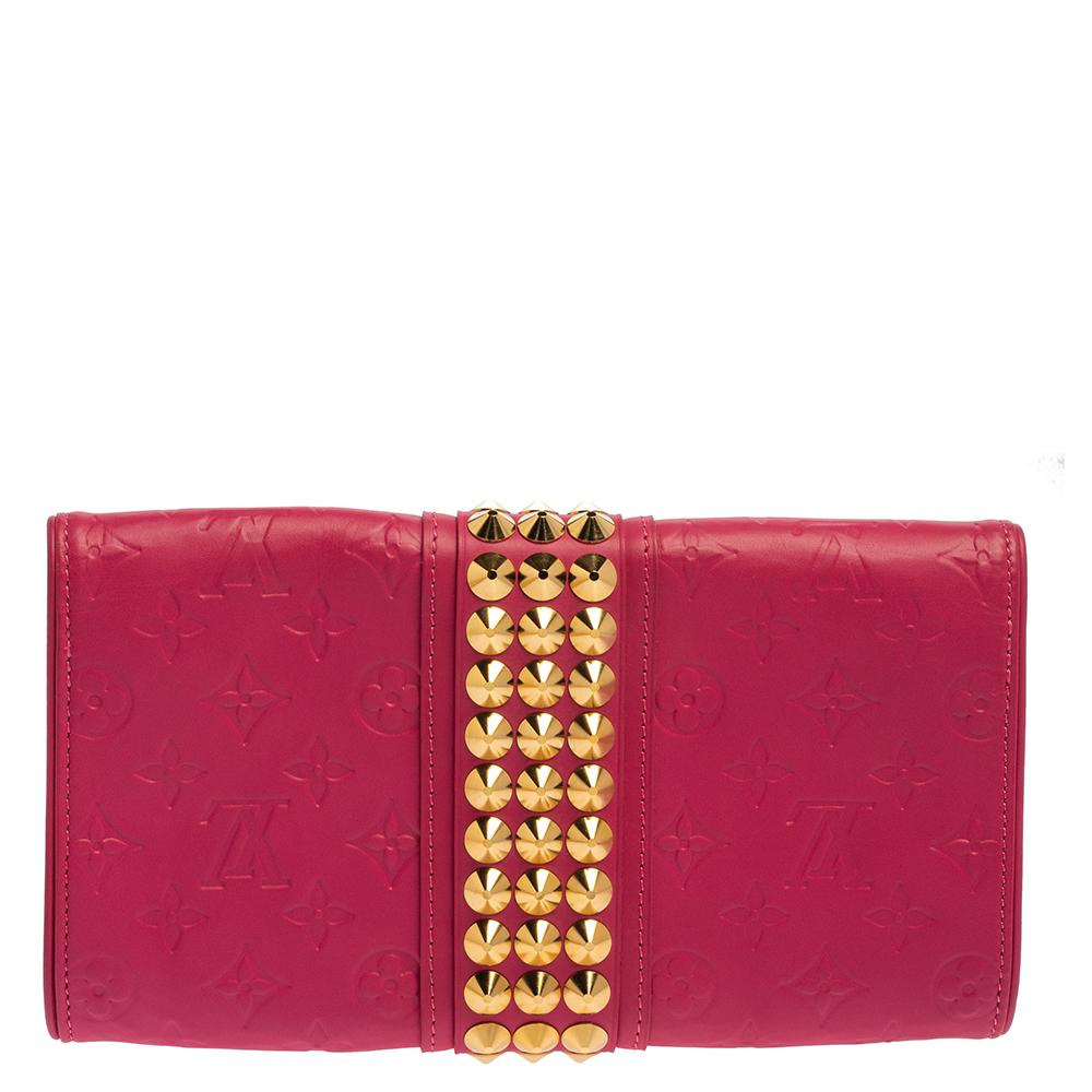 Louis Vuitton brings you this gorgeous clutch that has been crafted from monogram leather and styled in a flap design. It carries a bright pink shade, a well-sized suede-leather interior, and gold-tone hardware running along the middle.

Includes:
