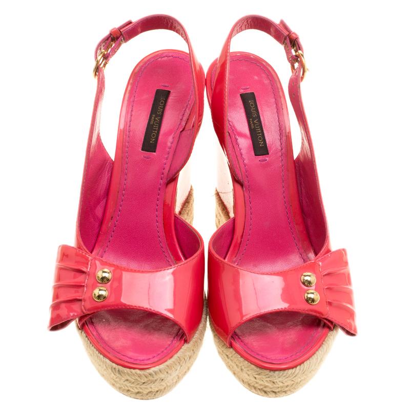 Set on a chunky espadrille wedge platform, these Louis Vuitton sandals are crafted in a bubbly pink patent leather body and features a peep-toe silhouette. It comes with a frontal strap detailed with pleats and gold-tone hardware and an ankle strap