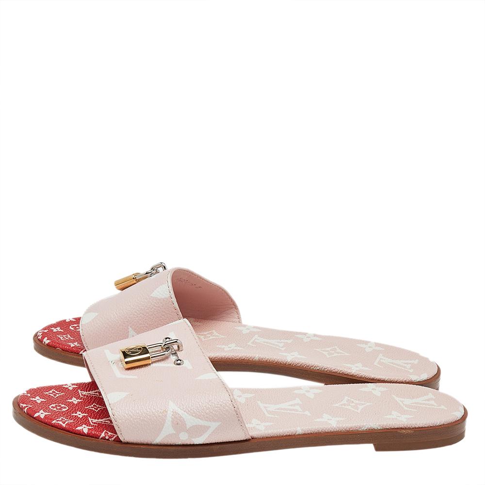 Present your feet with utmost comfort by choosing these 'Lock It' flat slides from the iconic house of Louis Vuitton. They are crafted from the signature monogram canvas and detailed with gold and silver-tone 'LV' padlocks on the vamp straps. They