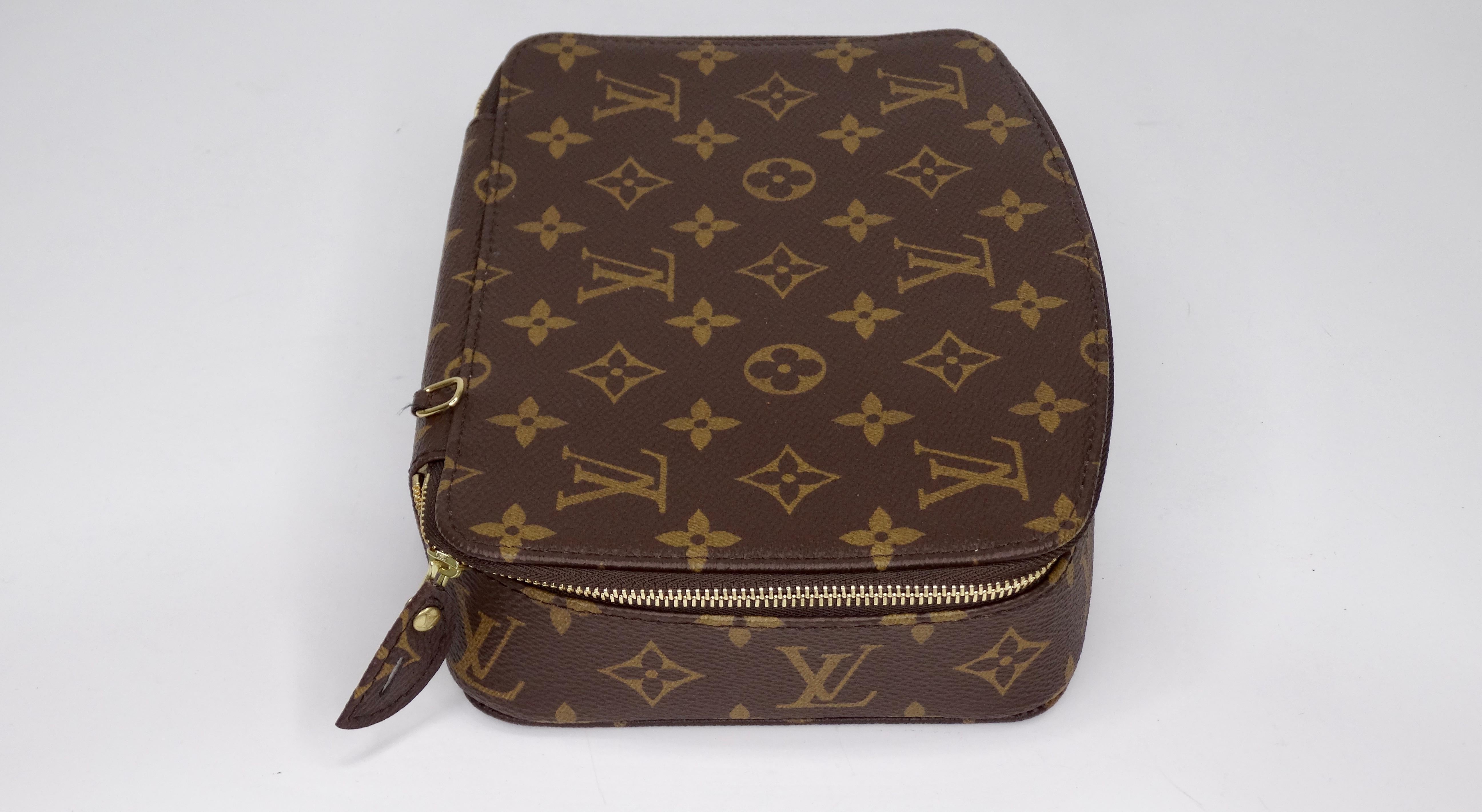 Get ready to travel! Circa 2017, this travel jewelry box features the signature LV monogram on the exterior. The LV zipper closure opens up to a suede interior with various jewelry holders and an attached three zip compartment pouch. Stamped Louis