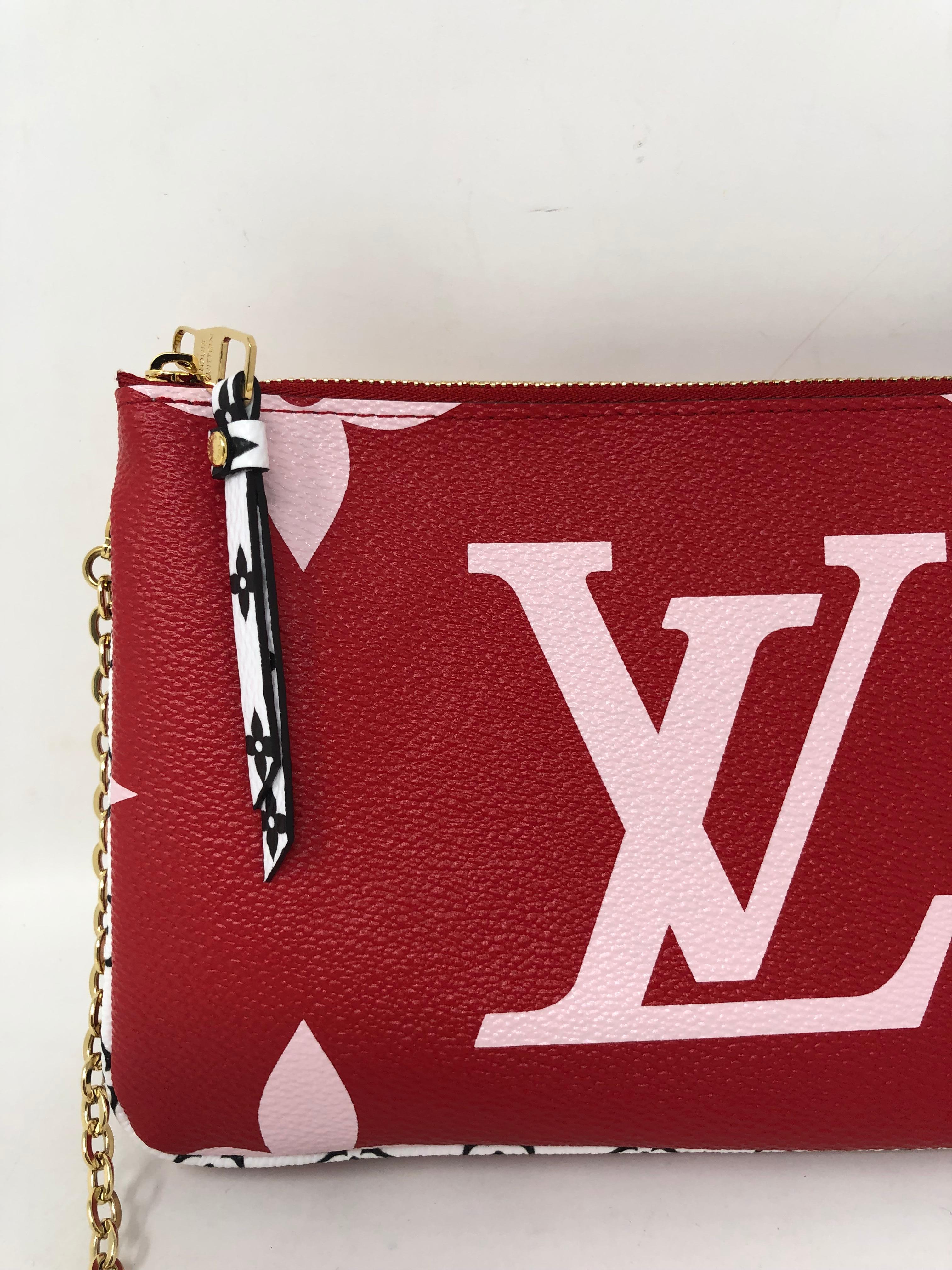Louis Vuitton Pochette Double Zip Mono Giant in Red/ Pink. Brand new. Limited and rare. Can be worn as a shoulder bag with gold chain or as a clutch. Double zips each side. Can be worn as a wallet on a chain too. Includes dust cover and box.