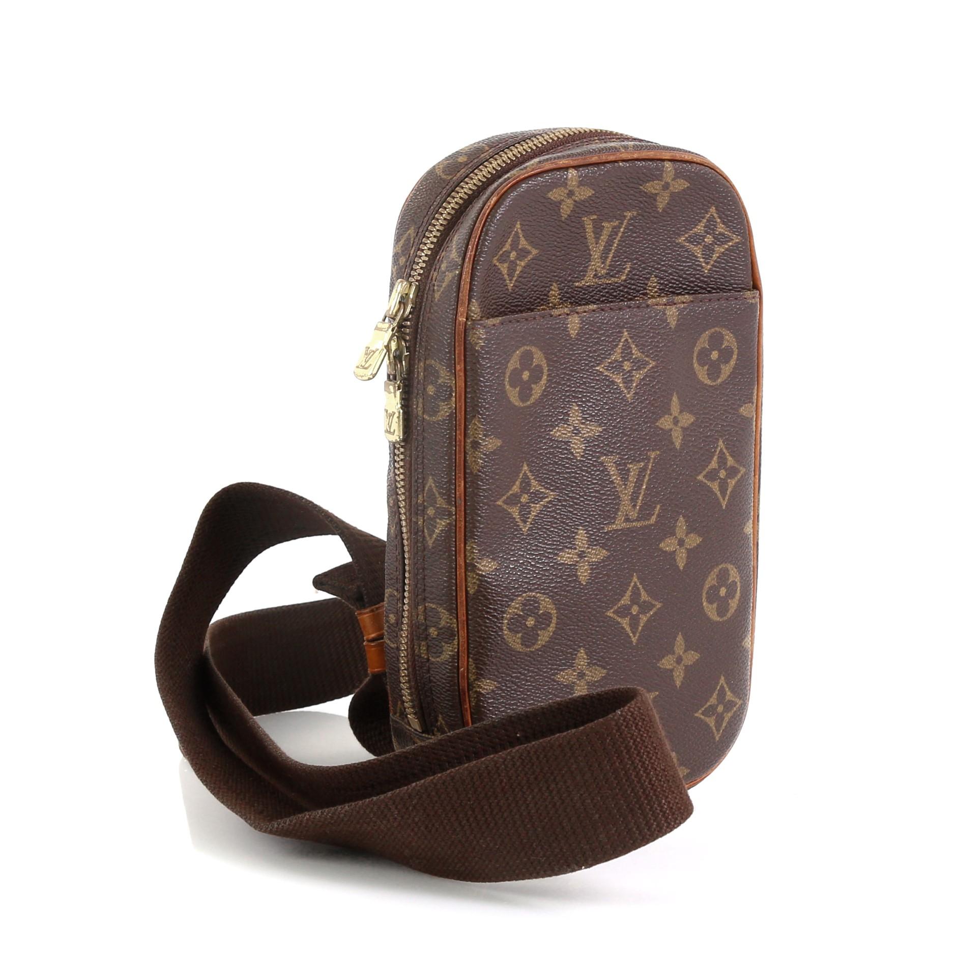 This Louis Vuitton Pochette Gange Monogram Canvas, crafted from brown monogram coated canvas, features an adjustable textile strap, exterior front pocket, and gold-tone hardware. Its zip closure opens to a brown fabric interior. Authenticity code