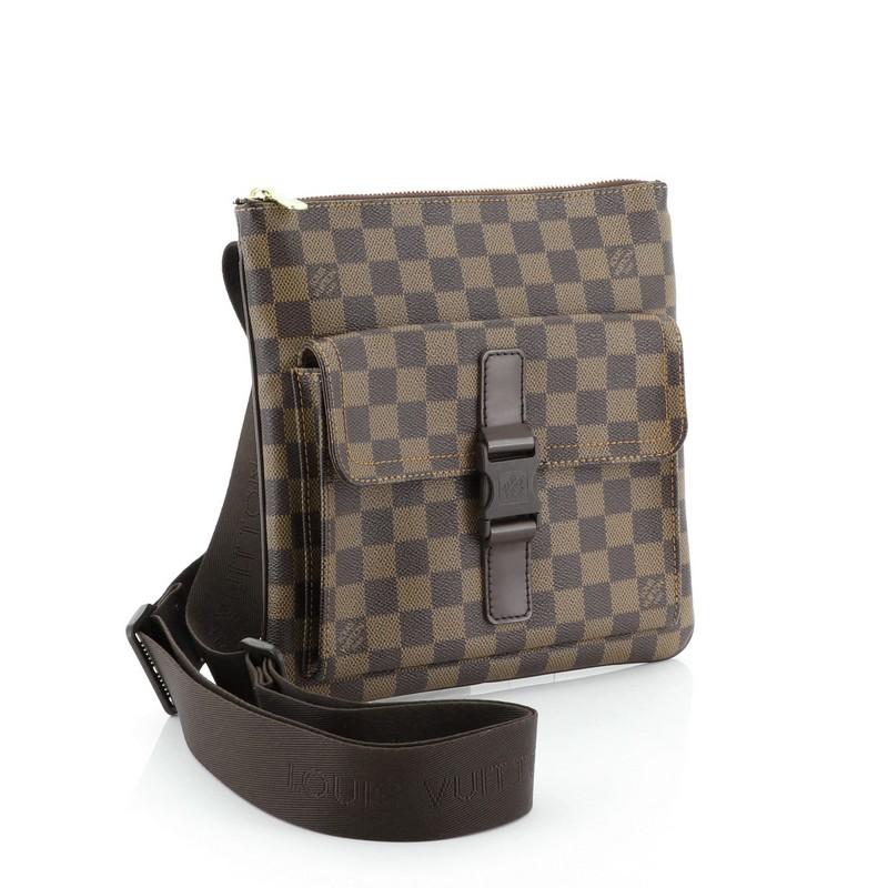 This Louis Vuitton Pochette Melville Damier, crafted from damier ebene coated canvas, features adjustable shoulder straps, front pocket with buckle closure, and gold-tone hardware. Its zip closure opens to a brown fabric interior. Authenticity code