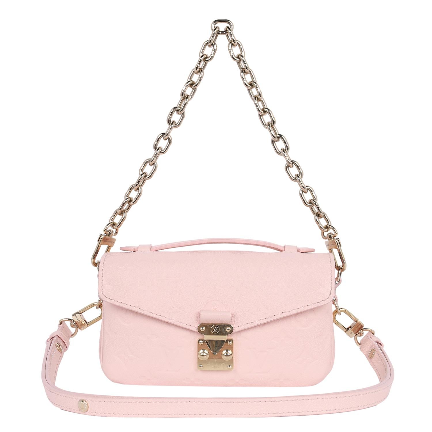 Authentic, pre-owned Louis Vuitton Pink Pochette Metis East West Leather Crossbody Bag. Features pink Monogram Empreinte embossed leather, top handle, adjustable shoulder strap, gold chain strap to use as a shoulder bag, front gold S lock closure,
