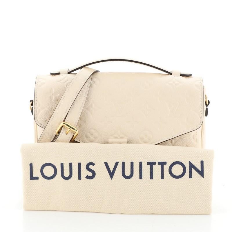 This Louis Vuitton Pochette Metis Monogram Empreinte Leather, crafted in neutral monogram empreinte leather, features a leather top handle, exterior back zip pocket, and gold-tone hardware. Its S-lock closure opens to a neutral fabric interior with