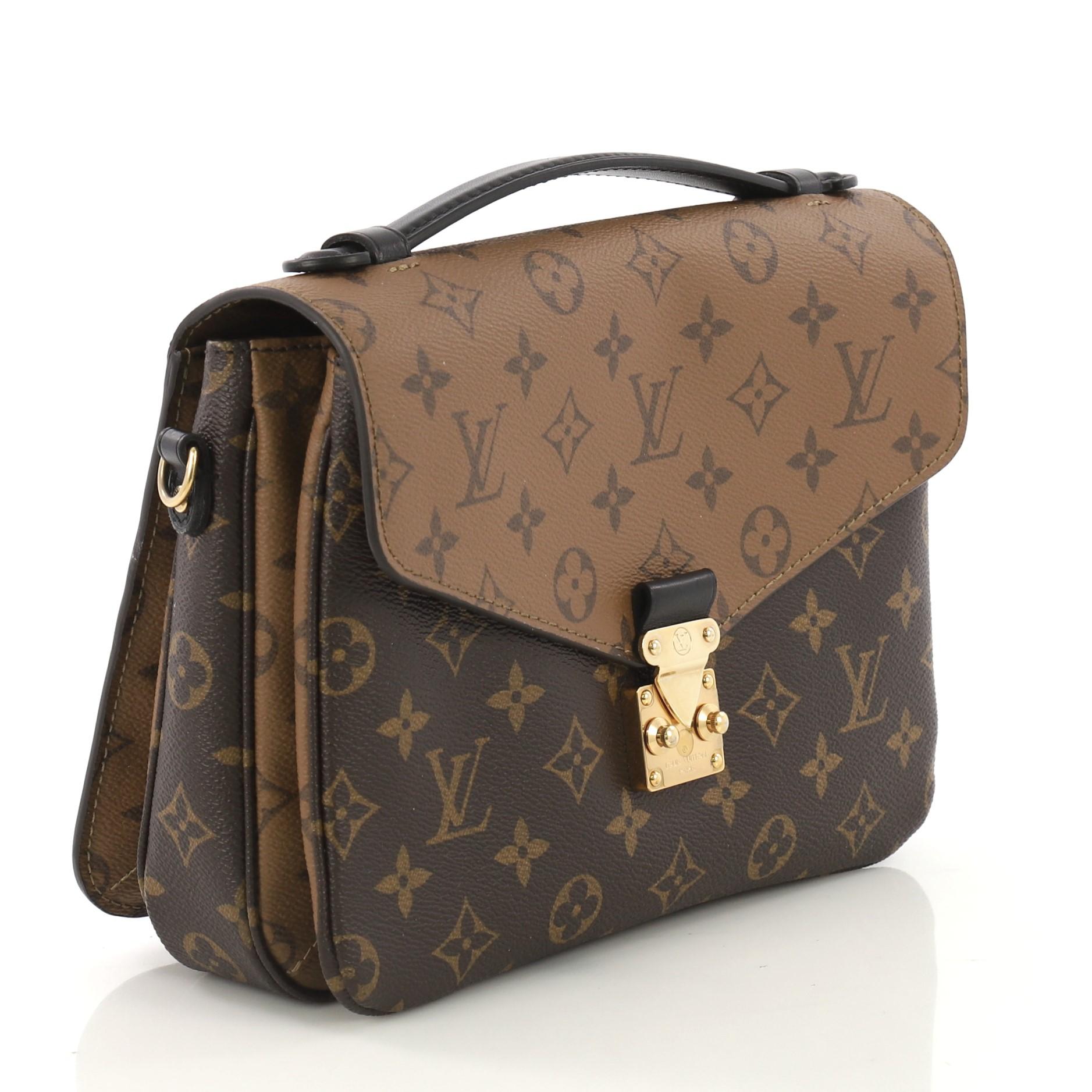 This Louis Vuitton Pochette Metis Reverse Monogram Canvas, crafted from brown reverse monogram coated canvas, features a top leather handle, exterior back zip pocket, and gold-tone hardware. Its s-lock closure opens to a black fabric interior