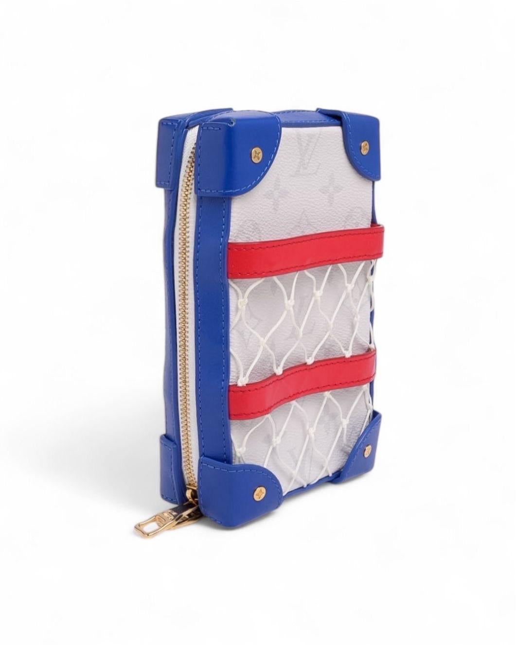 Pochette firmata Louis Vuitton, modello Trunk Soft in Edizione Limitata, frutto della collaborazione esclusiva con l’NBA. Realizzata in tela bianca con rifiniture in pelle rossa e blu e impreziosita da hardware dorati, questa pochette unisce