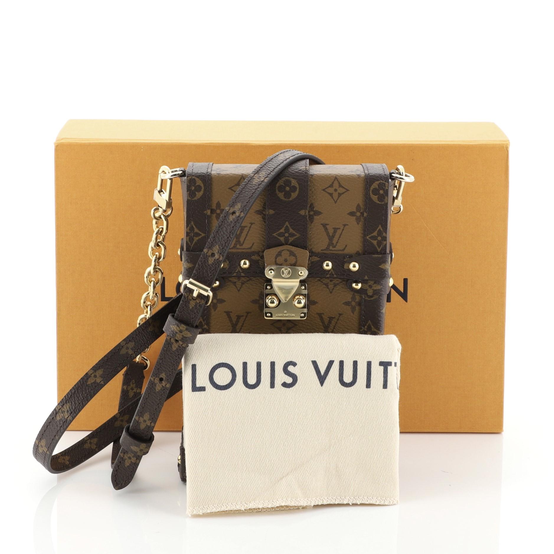 This Louis Vuitton Pochette Trunk Verticale Reverse Monogram Canvas, crafted in reversed brown monogram coated canvas, features and adjustable strap brown monogram trims, classic trunk details and gold-tone hardware. Its S-lock closure opens to a