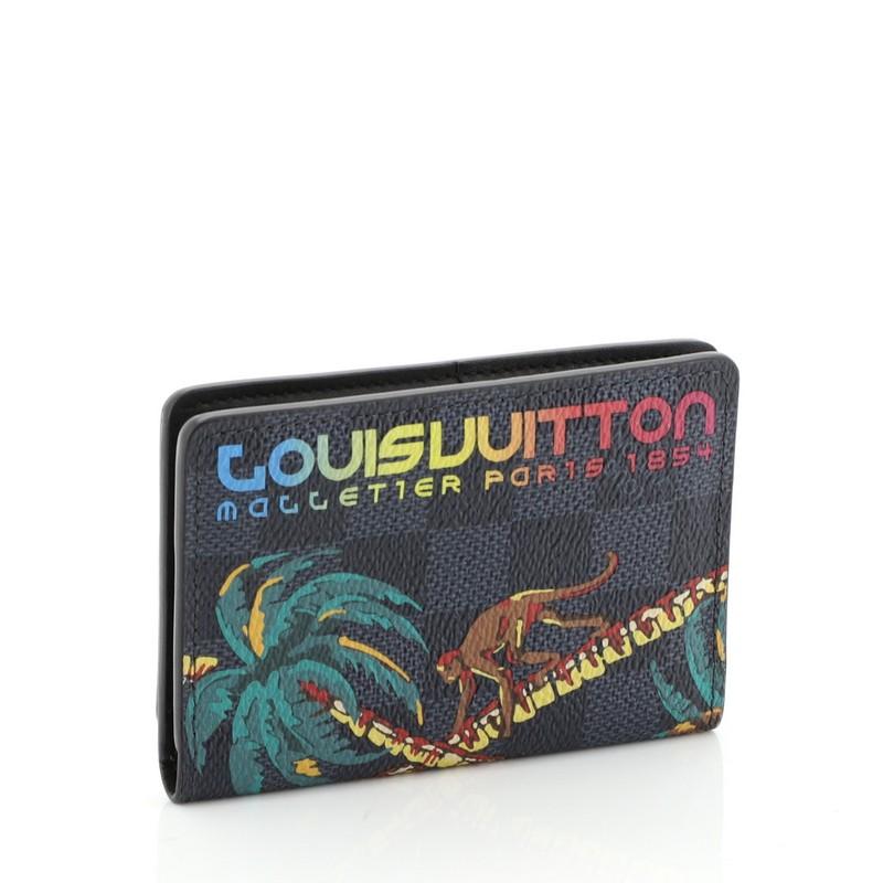 This Louis Vuitton Pocket Organizer Limited Edition Damier Cobalt Jungle, crafted in damier cobalt coated canvas, features the Jungle theme with playful palm tree print and rainbow Louis Vuitton signature. It opens to a black leather interior with