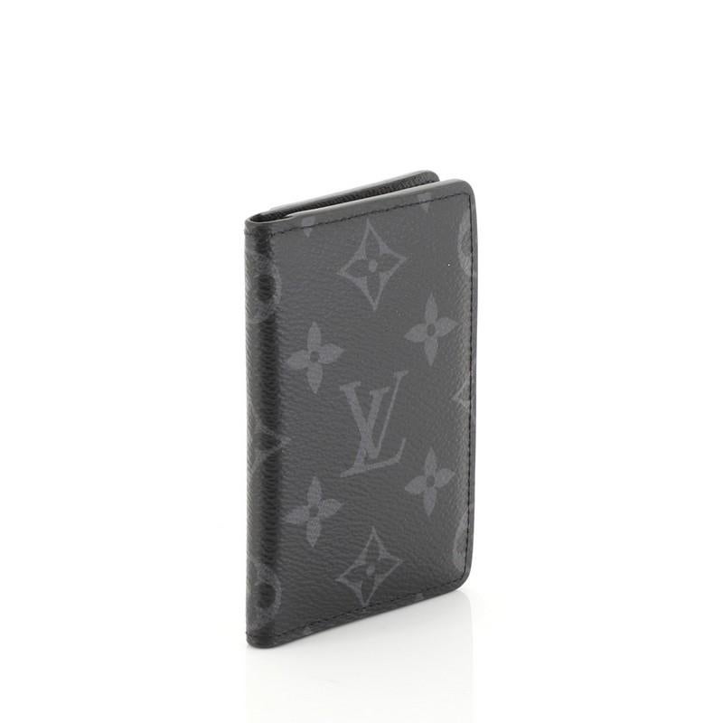This Louis Vuitton Pocket Organizer Monogram Eclipse Canvas, crafted in monogram eclipse coated canvas. It opens to a black leather interior with multiple card slots. Authenticity code reads: CT1178. 

Estimated Retail Price: $350
Condition: Great.