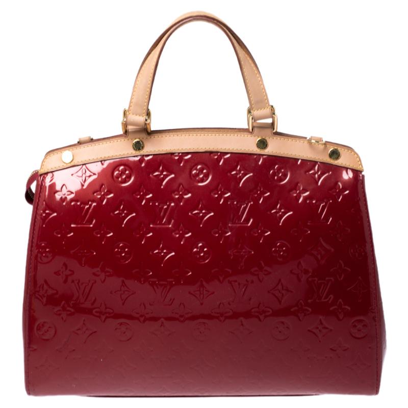 The feminine shape of Louis Vuitton's Brea is inspired by the doctor's bag. Crafted from Monogram Vernis in red, the bag has a perfect finish. The fabric interior is spacious and it is secured by a zipper. The bag features double handles, protective