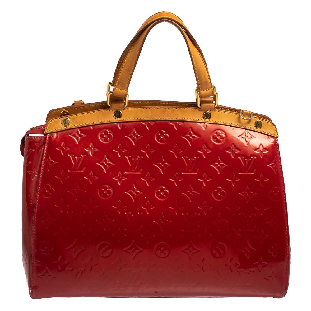 The feminine shape of Louis Vuitton's Brea is inspired by the doctor's bag. Crafted from Monogram Vernis leather in red, the bag has a perfect finish. The fabric interior is spacious and it is secured by a zipper. The bag features double handles,