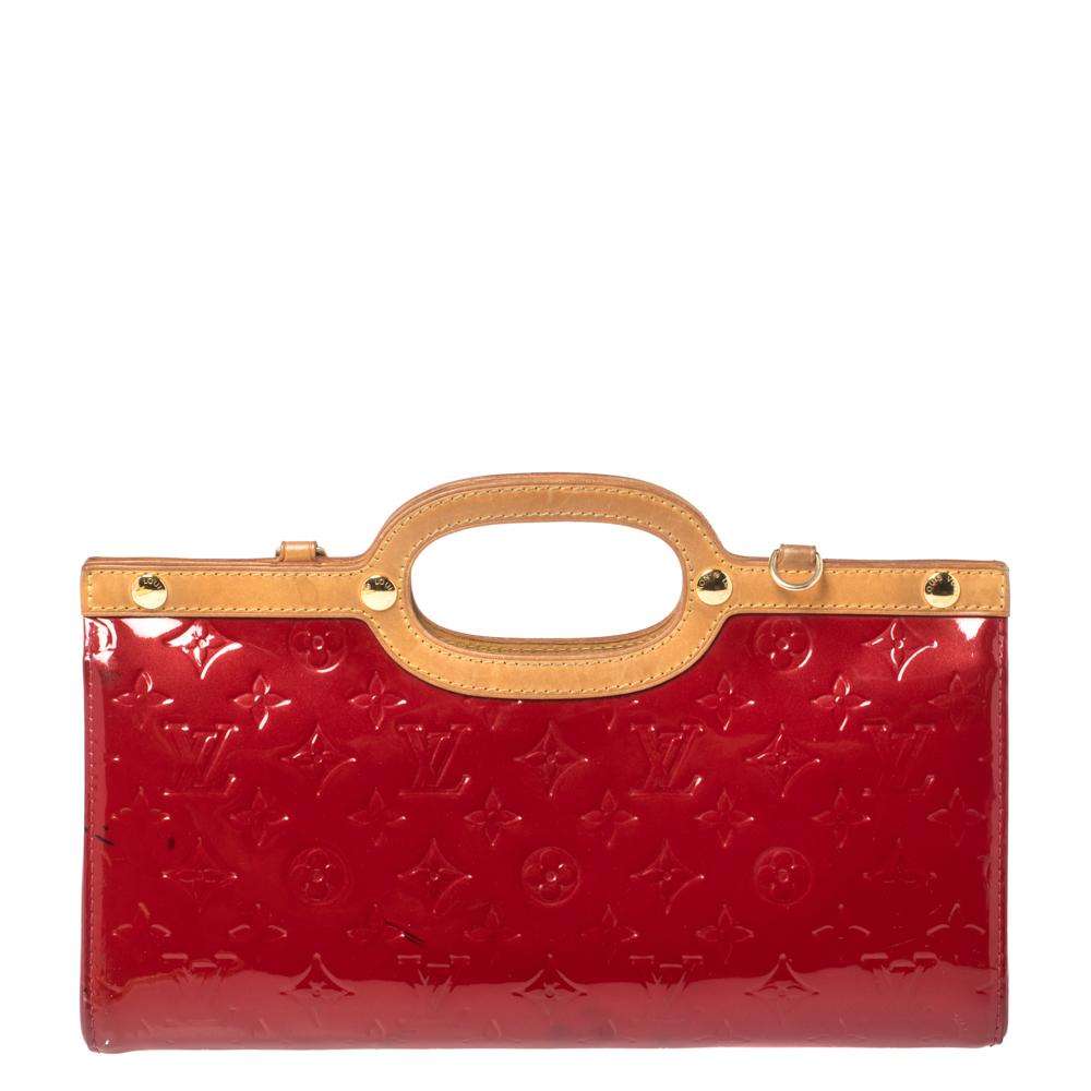 This Roxbury Drive bag from Louis Vuitton is sure to make heads turn. The monogram pattern is embossed on the patent leather body that gives it a polished look. The red-colored exterior features smooth trims, a removable shoulder strap, and