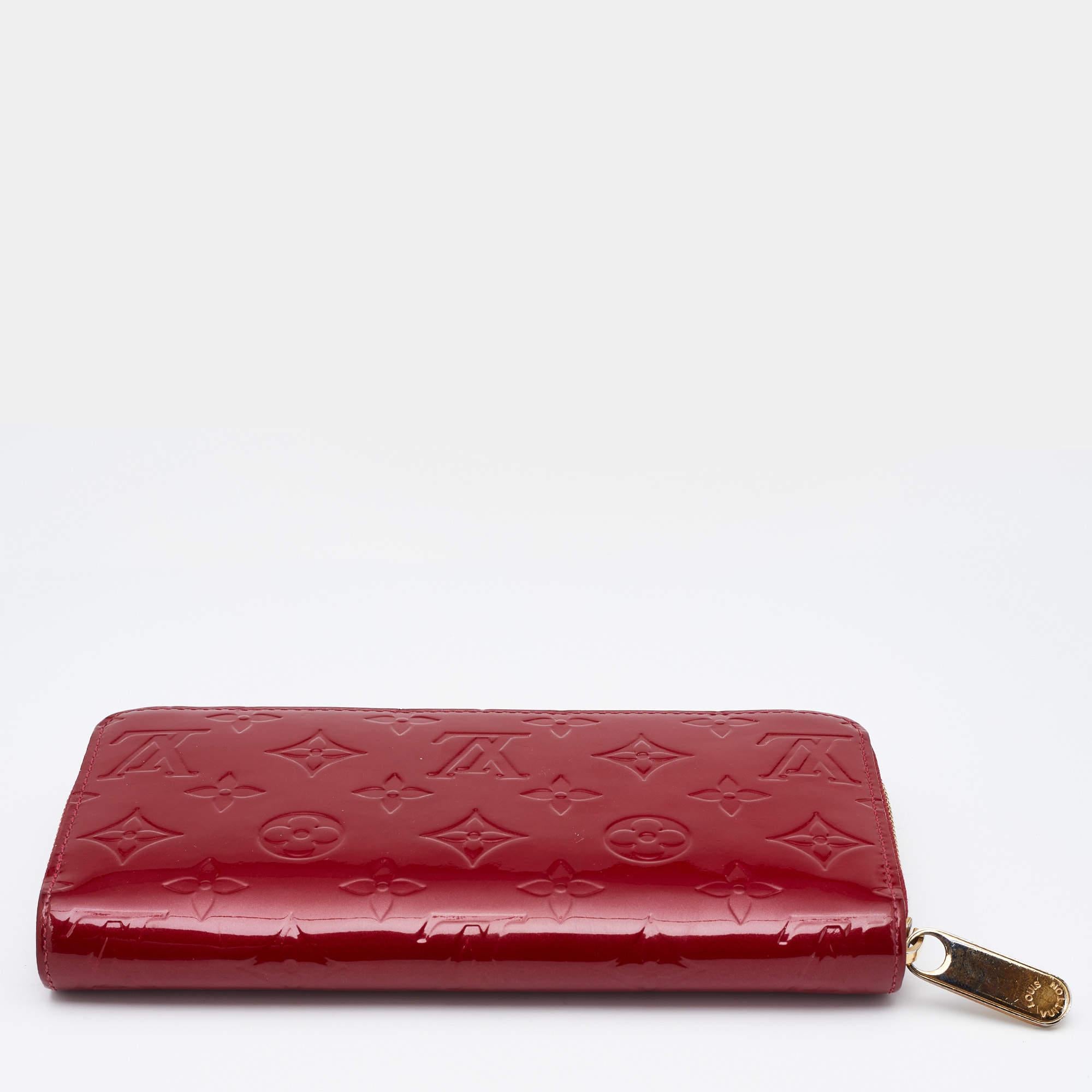 This Louis Vuitton Zippy wallet is conveniently designed for everyday use. Crafted from Pomme D’amour Monogram Vernis canvas, it is paired with a zip-around closure and gold-tone hardware. The compartmentalized interior of the wallet will store your