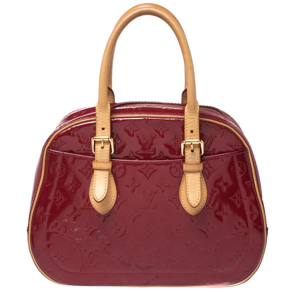 Well-made and essaying luxury, this Louis Vuitton bag will take you through your day with ease. Crafted from Pomme D’amour Monogram Vernis leather, it features dual tan handles and exterior slip pockets. The bag is secured by a wide two-way zip