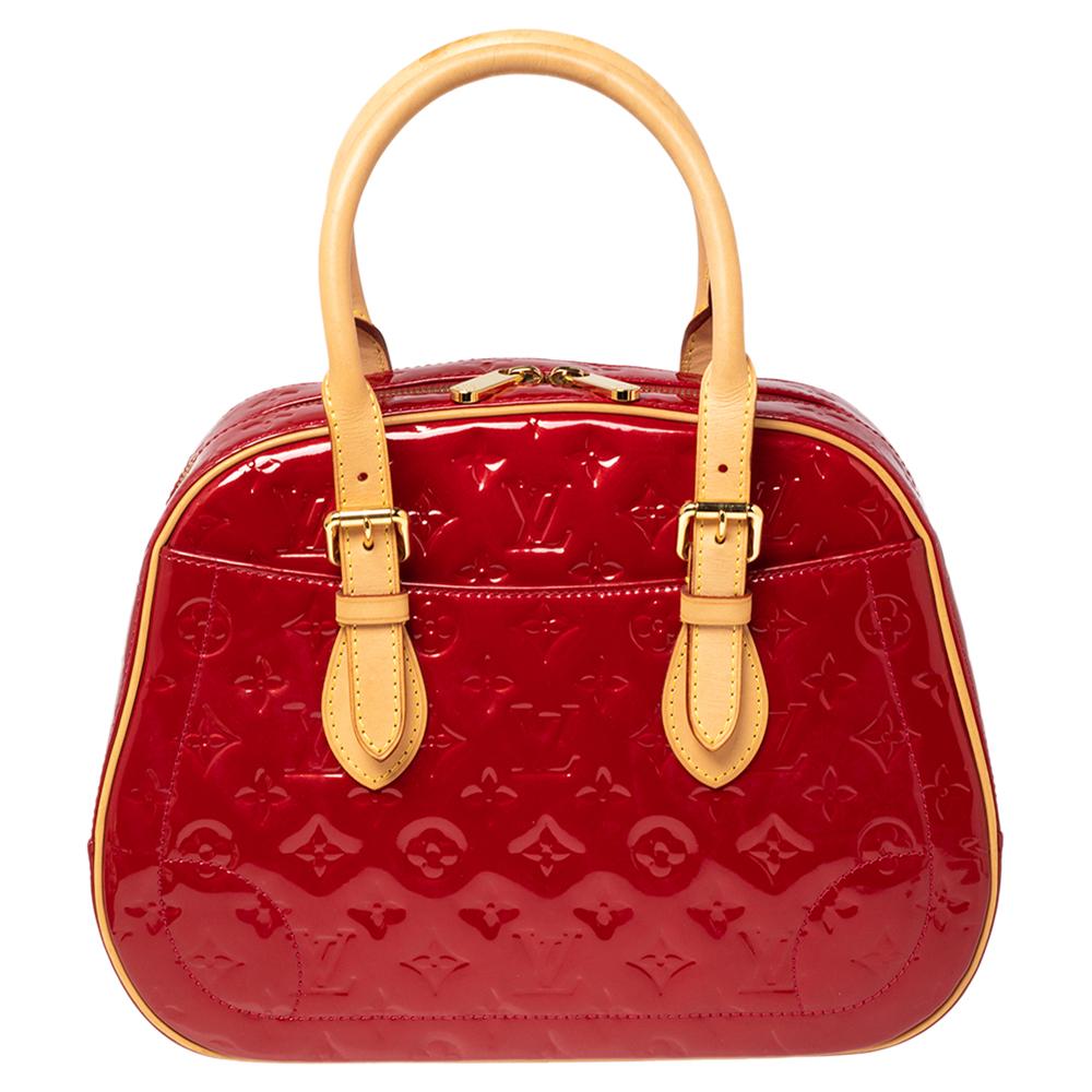Elegante e strutturata, questa borsa ti accompagna nella tua giornata con facilità. Realizzata in un'elegante silhouette di Pomme D'amour Vernis, la borsa presenta doppi manici arrotolati e tasche esterne a scomparsa. La borsa è assicurata da