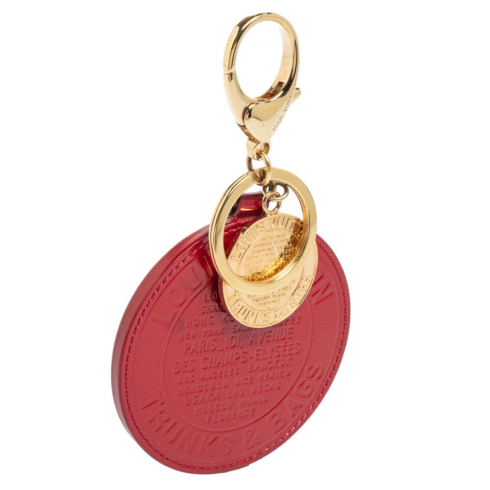 Accessorize your bags with this Trunks & Bags Limited Edition charm from Louis Vuitton. It is made from Pomme D'Amour Vernis leather and gold-toned metal with a lobster clasp for attachment. Can be used as a bag charm or a keyring.

