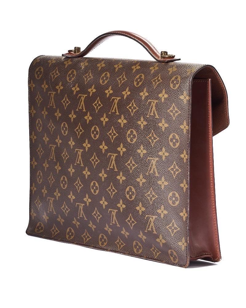 Portadocumenti firmato Louis Vuitton, modello serviette nella misura GM, realizzato in tela marrone nella classica fantasia monogram con rifiniture in pelle e hardware dorato. Dotato di una patta frontale con chiusura ad incastro, internamente