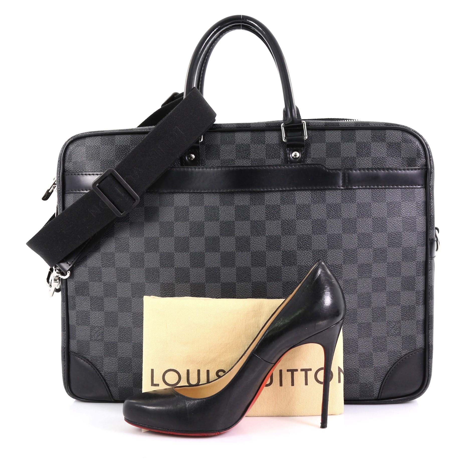 This Louis Vuitton Porte-Documents Voyage Briefcase Damier Graphite GM, crafted from damier graphite coated canvas, features dual rolled handles, black leather trim, and silver-tone hardware. Its top zip closure opens to a black fabric interior with