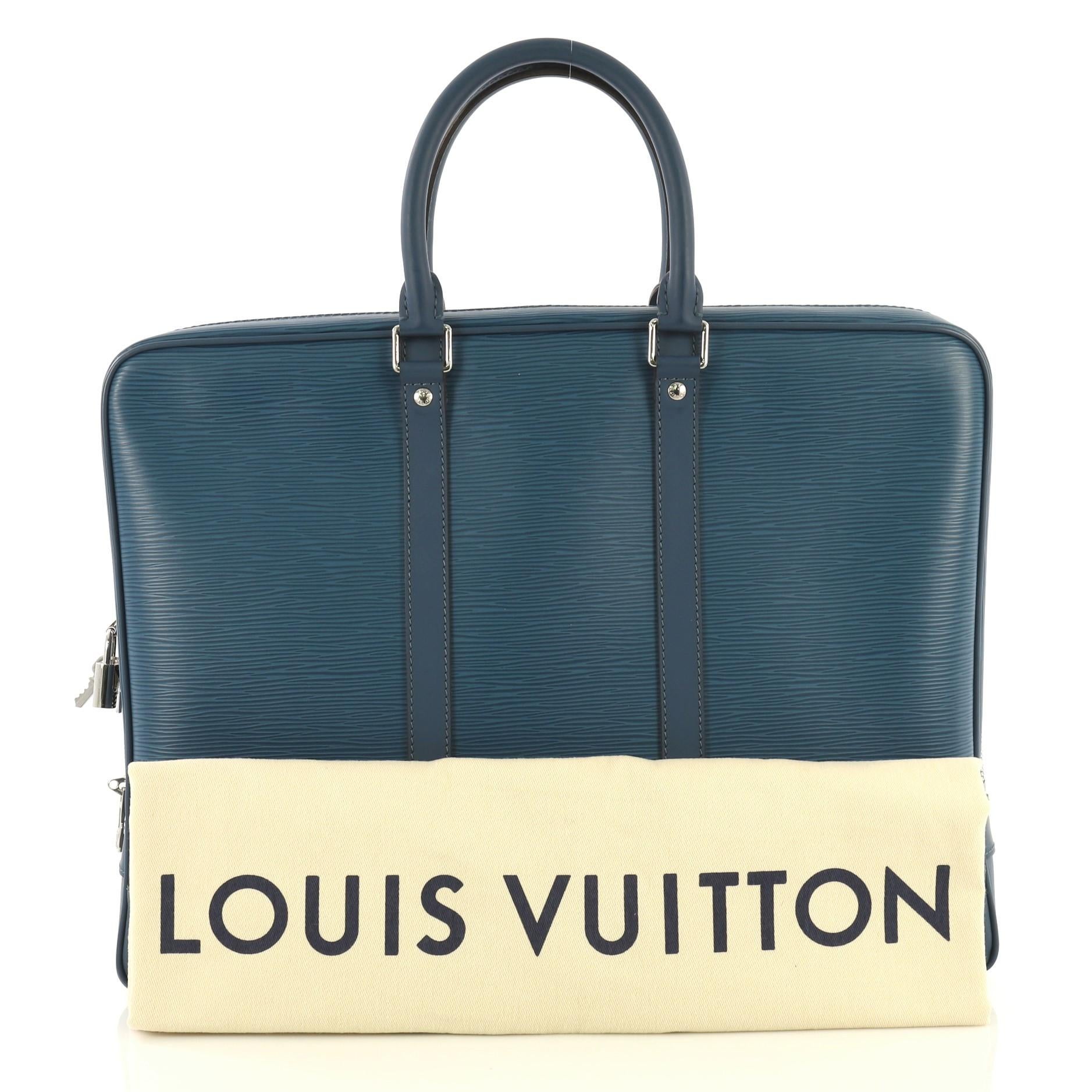 This Louis Vuitton Porte-Documents Voyage Briefcase Epi Leather, crafted in blue epi leather, features dual rolled handles, leather base corners, and silver-tone hardware. Its zip closure opens to a blue microfiber interior with side zip and slip