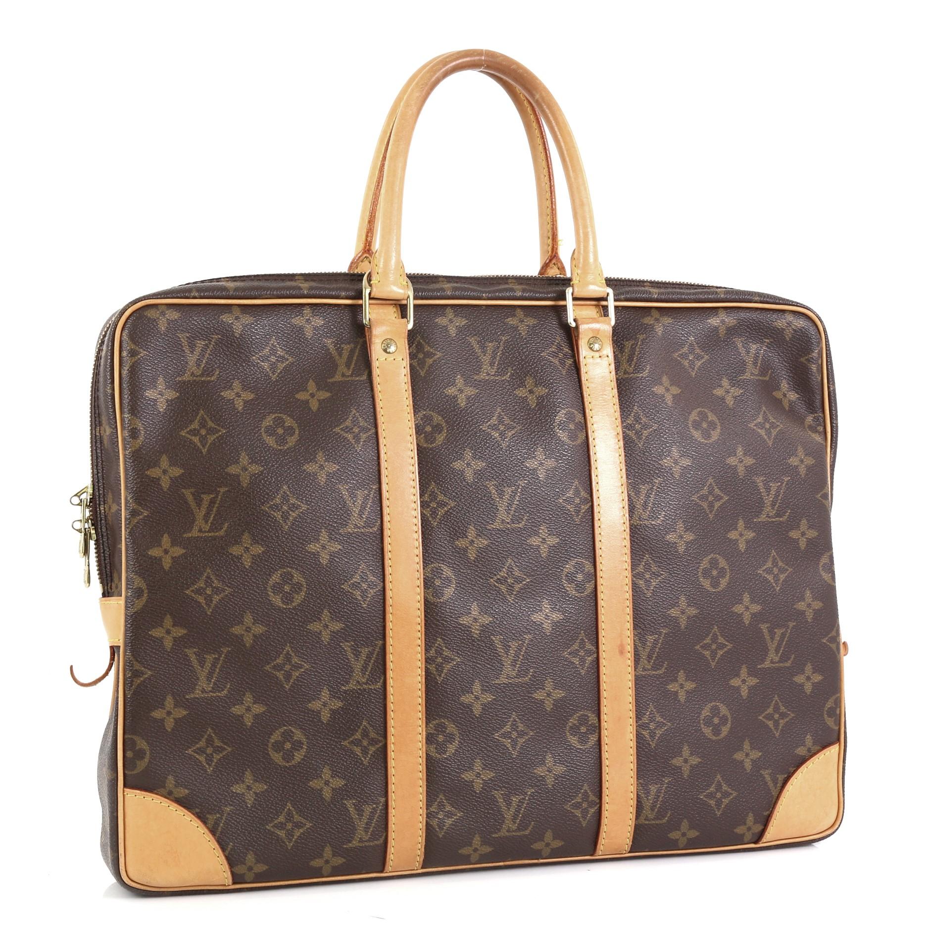 This Louis Vuitton Porte-Documents Voyage Briefcase Monogram Canvas, crafted from brown monogram coated canvas, features dual rolled handles, leather trim, and gold-tone hardware. Its zip closure opens to a brown leather interior with zip and slip