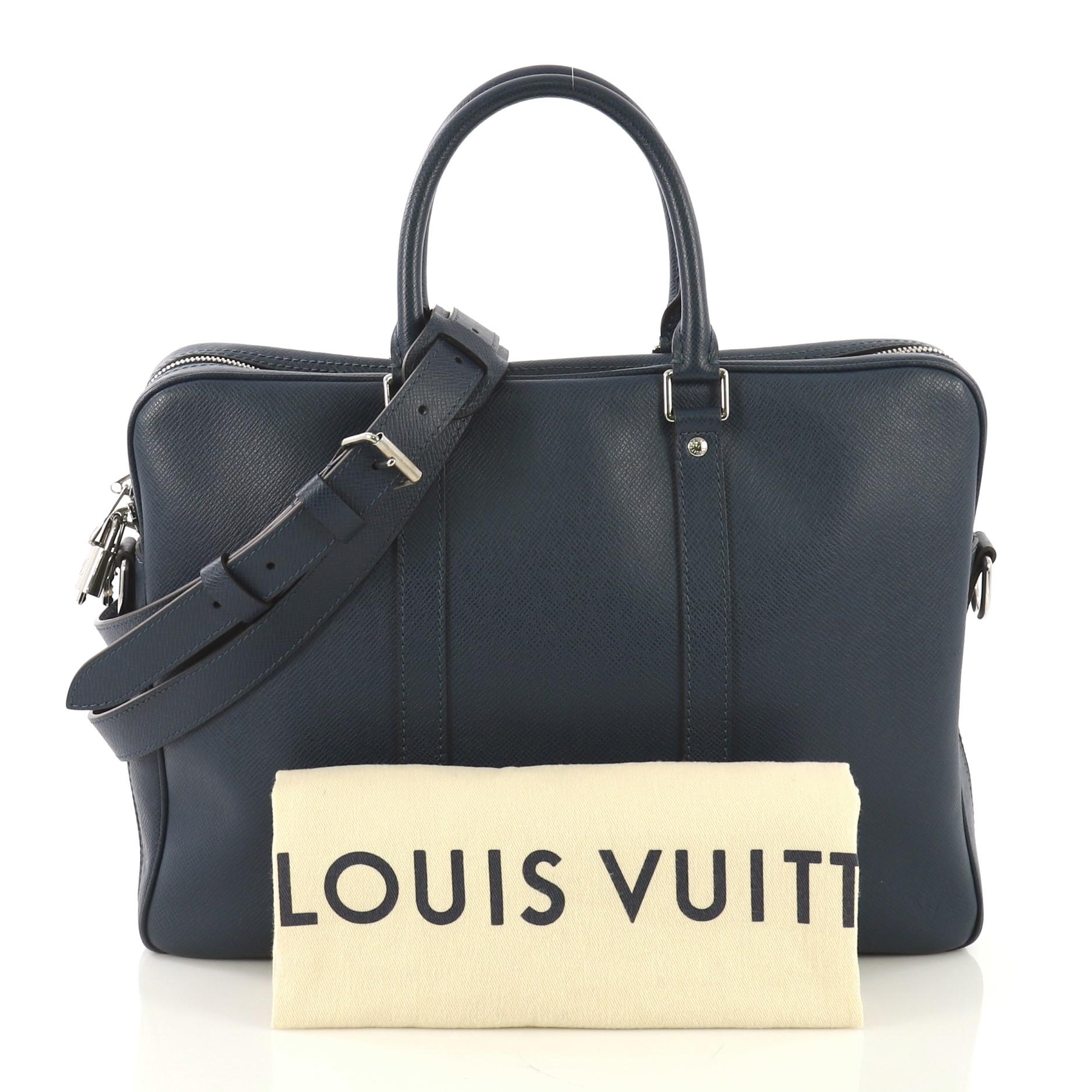 This Louis Vuitton Porte-Documents Voyage Briefcase Taiga Leather PM, crafted from blue taiga leather, features dual rolled handles and silver-tone hardware. Its two-way zip closure opens to a blue fabric interior with slip pockets. Authenticity