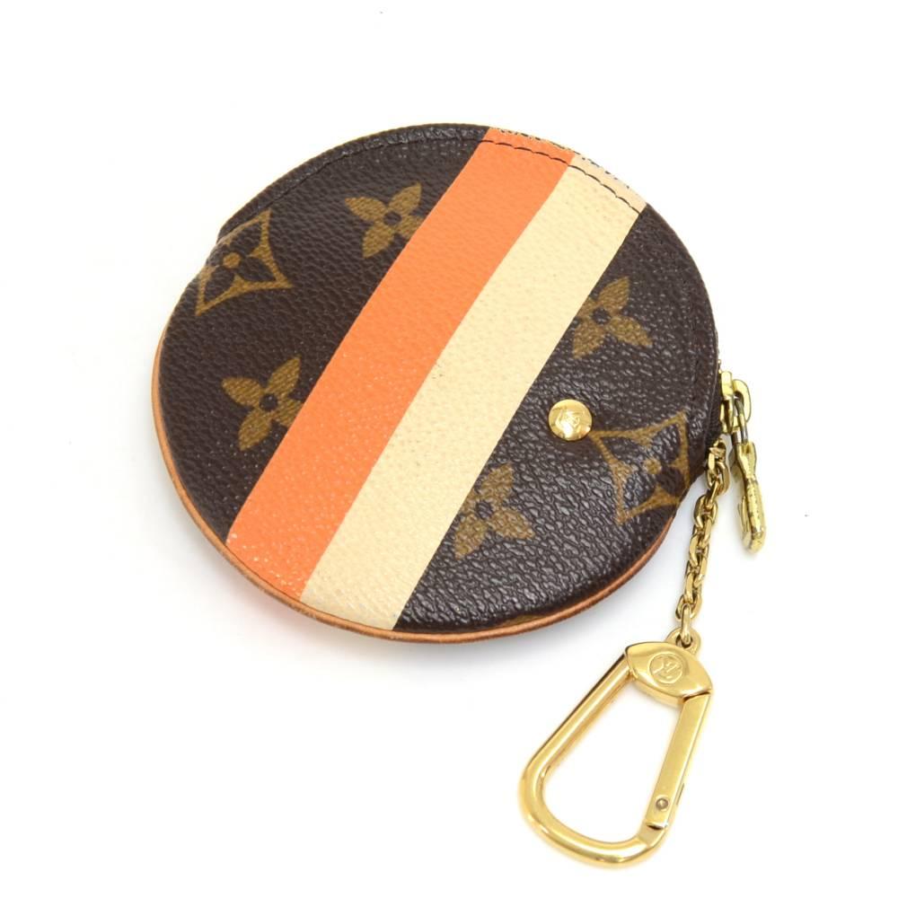 Louis Vuitton Porte Monnaie Round coin case in Monogram Groom Canvas -long discontinued the item.  It is a limited edition design featuring a groom boy/ page boy referring to Louis Vuitton's history as a luxury luggage brand. Inside has orange