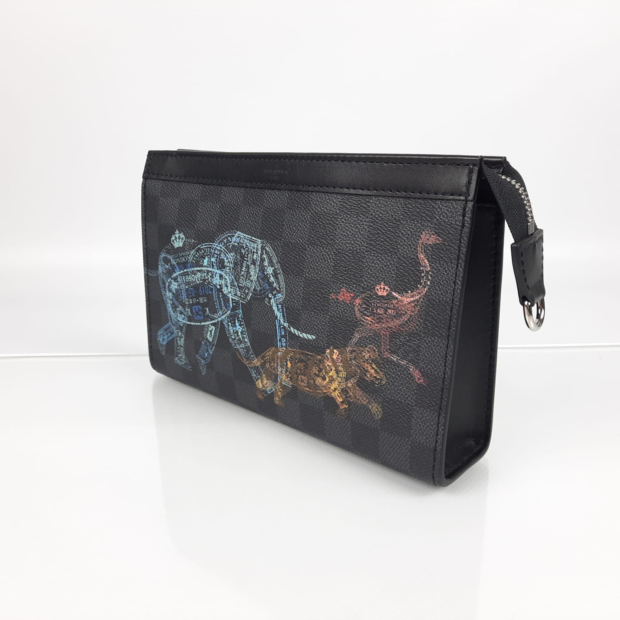 The pastel print made up of passport-style stamps depicts an elephant, a tiger and an ostrich wandering over the checkered pattern of the Damier Graphite canvas of this Gaston Wearable wallet. Inspired by the Pochette Voyage, it features a removable