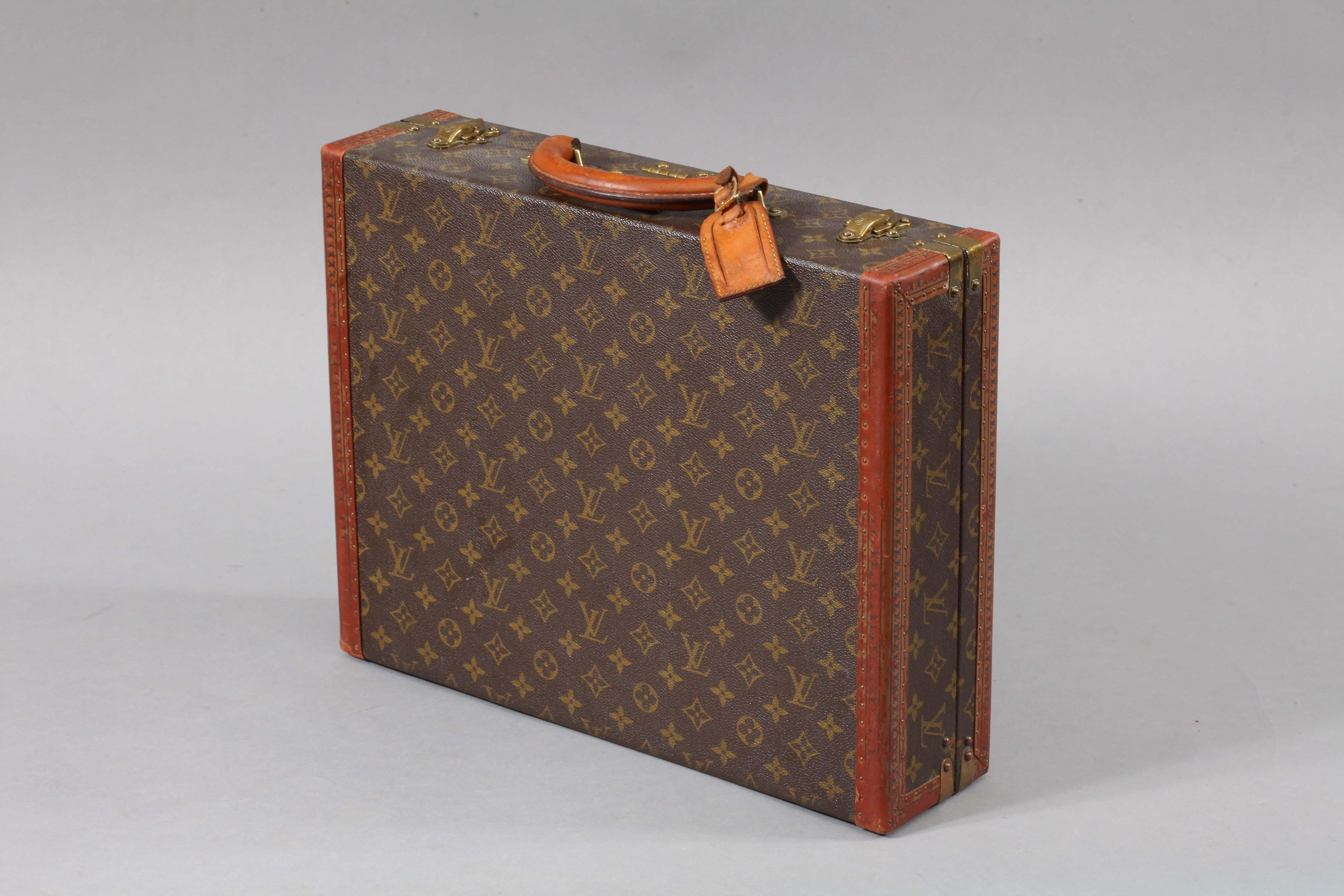 Louis Vuitton 'President' in LV monogram pattern with brass fittings and trimmed with lozine to the edges. The lid of the case is secured by a central sprung catch with lock as well as two latches. Brown leather lining to the interior and the inside