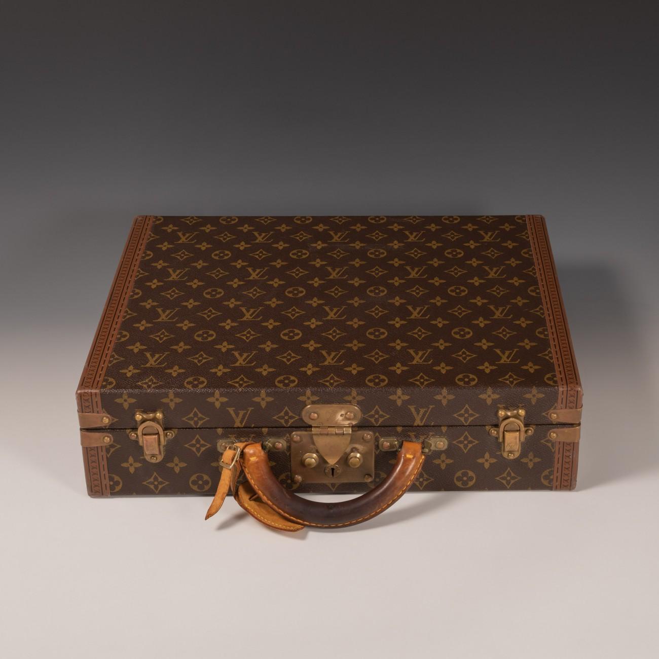 Louis Vuitton 'President' in LV monogram pattern with brass fittings and trimmed with lozine to the edges. The lid of the case is secured by a central sprung catch with lock as well as two latches. Brown leather lining to the interior and the inside